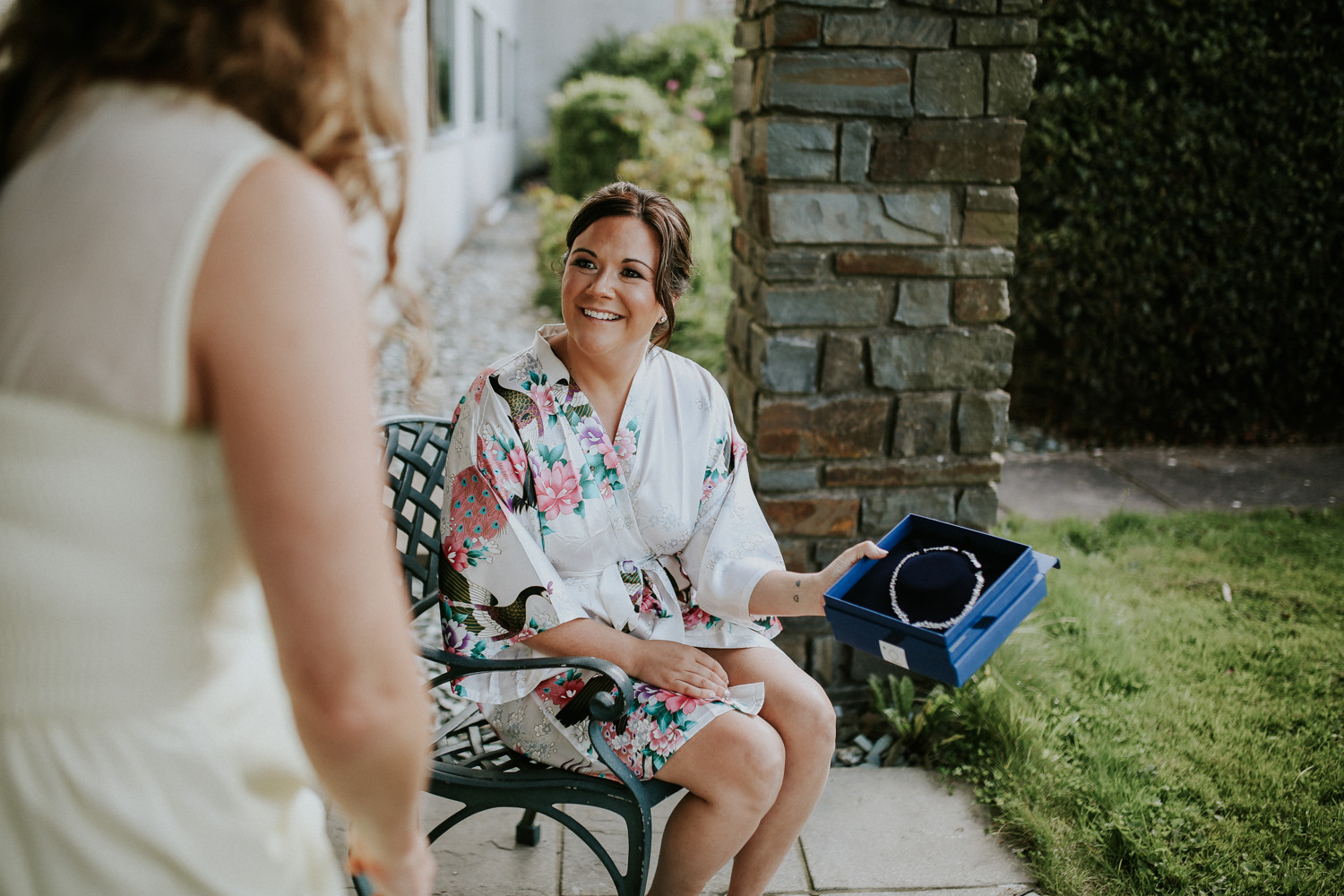 bride showing bridesmaid the gift from the groom