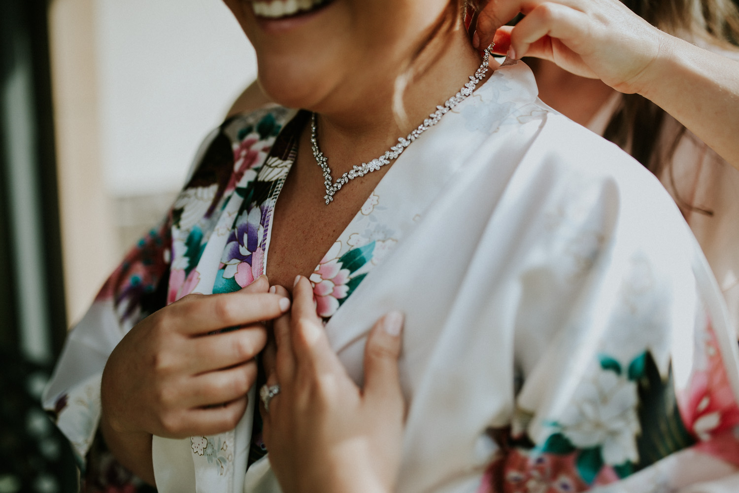 bride putting on necklace from the groom