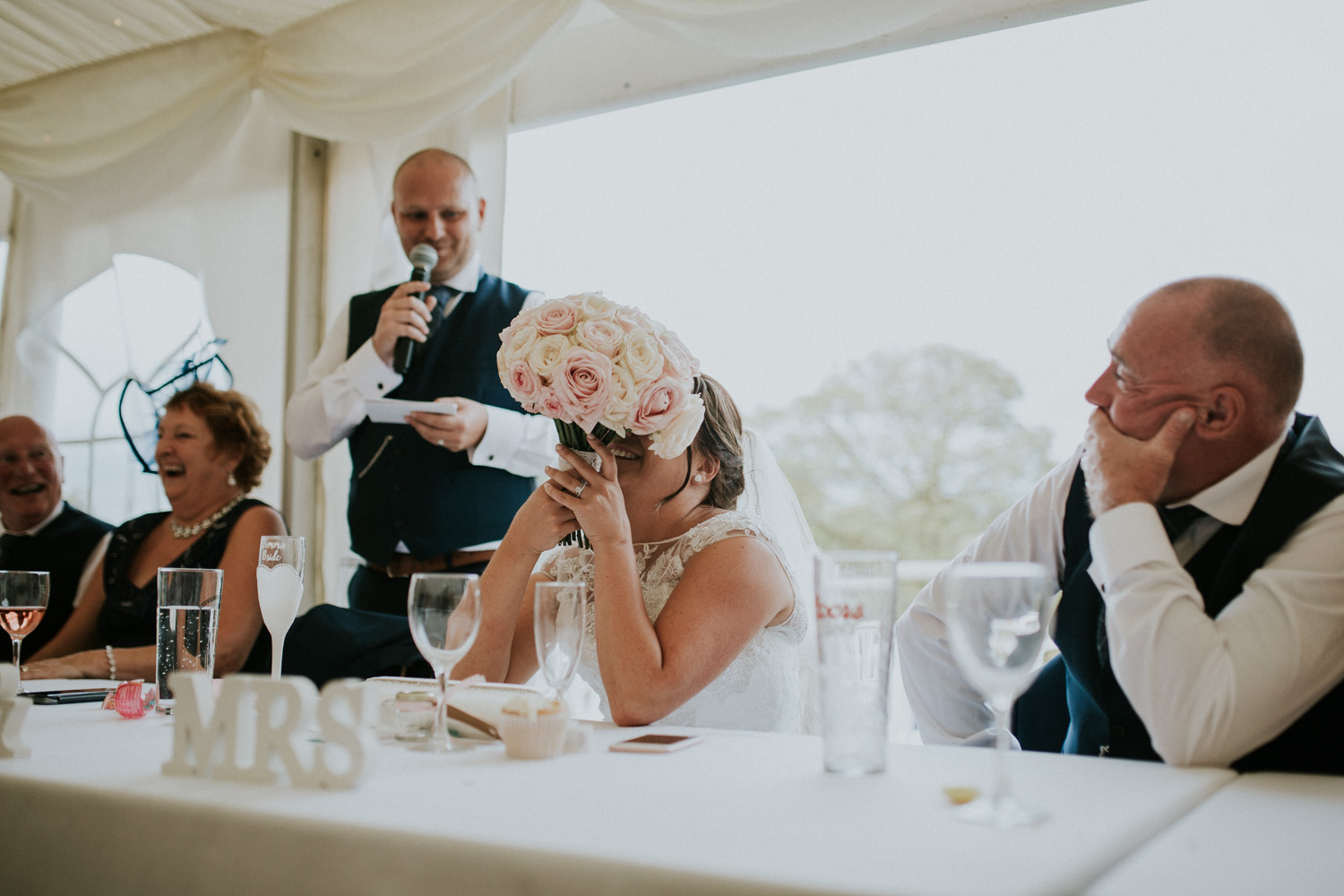 bride laughing at groom speech