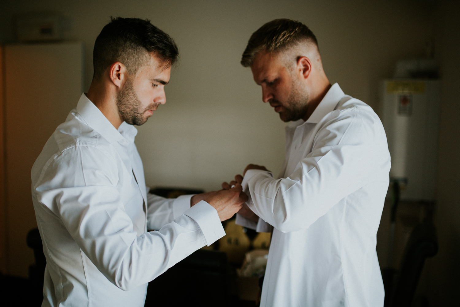 groomsmen helping with cufflinks