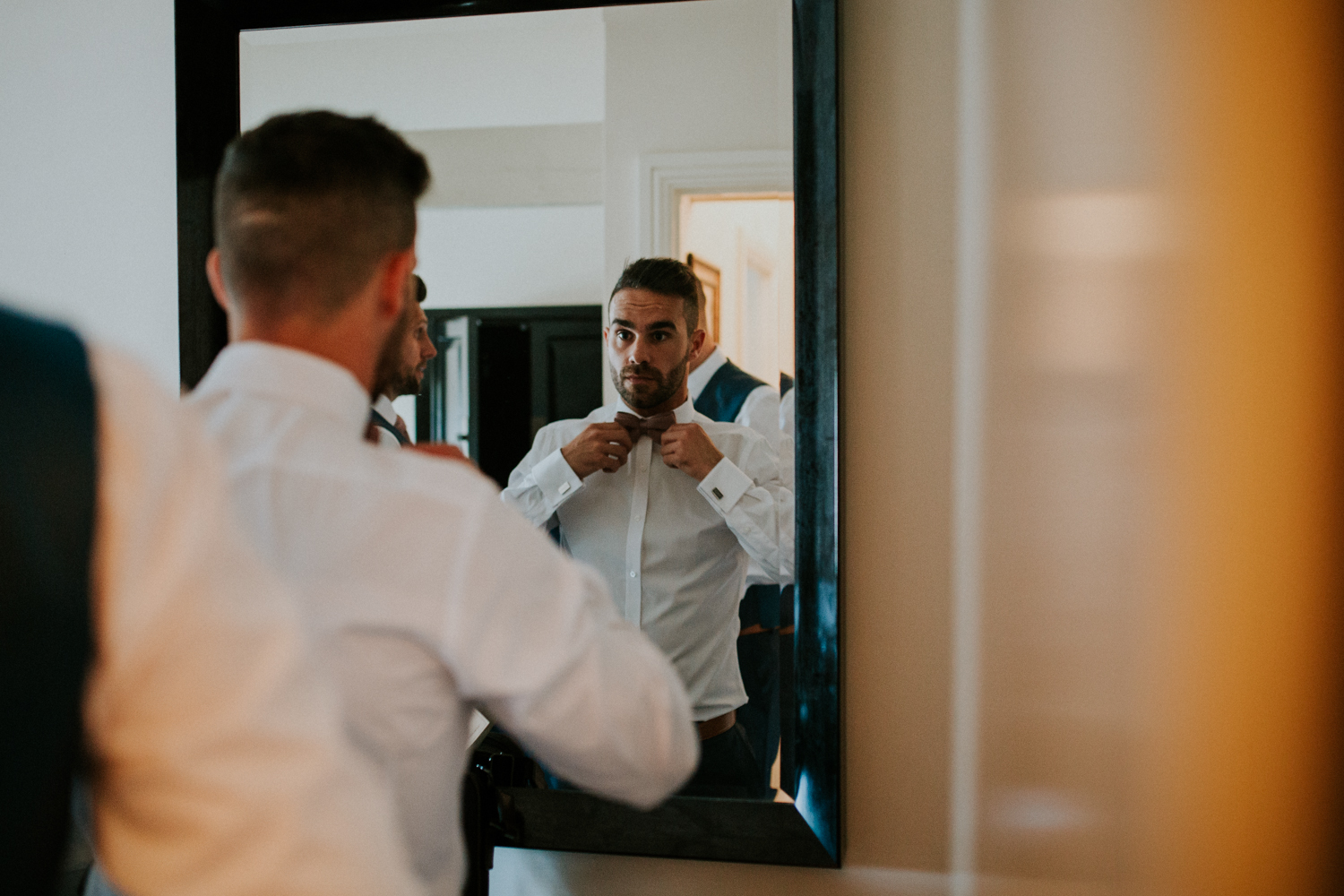 groom doing his tie