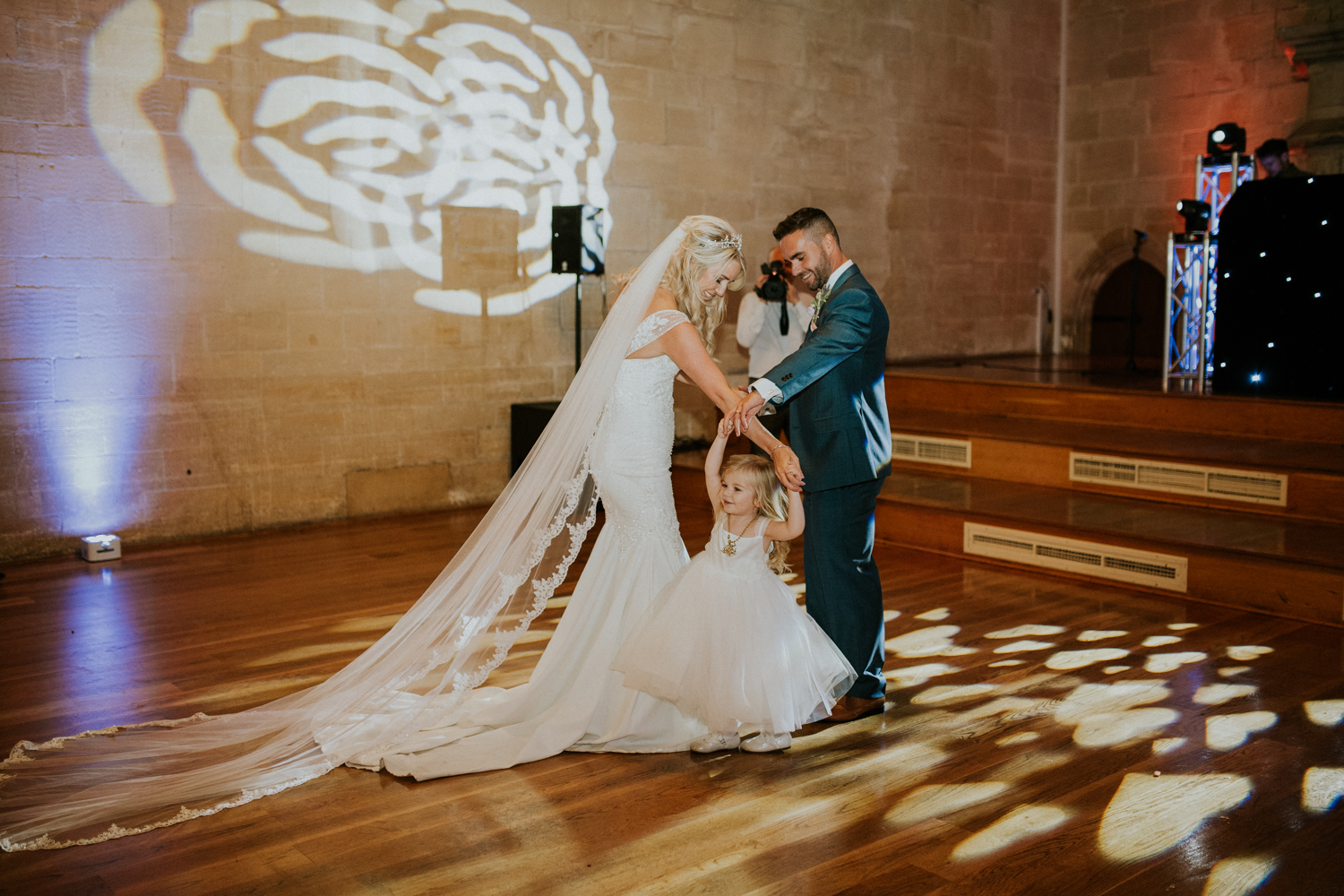 bride and groom first dance with flower girl