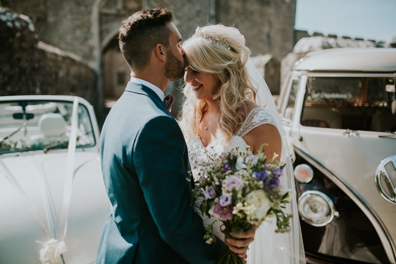 bride and groom by the wedding car