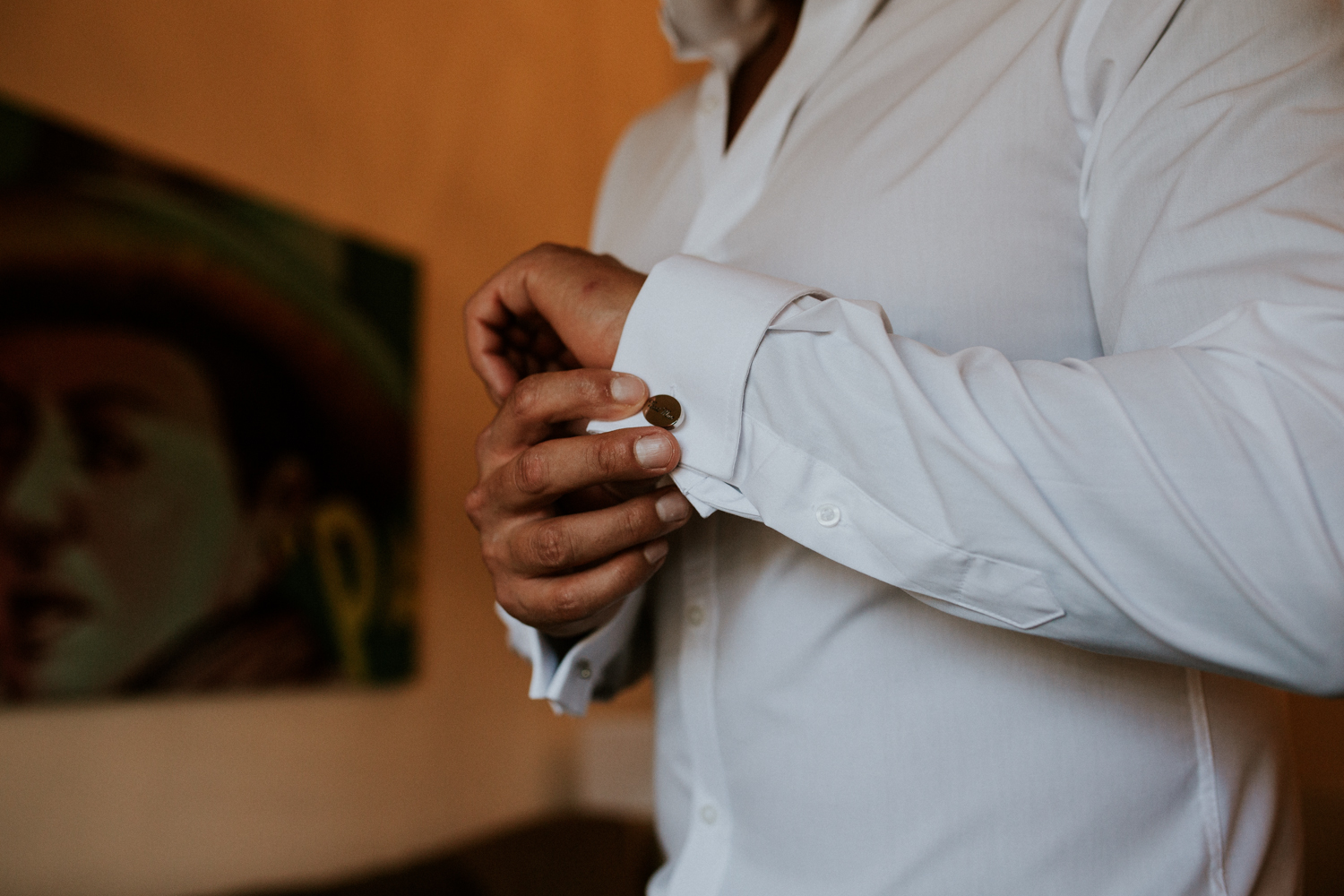 groom doing cufflinks