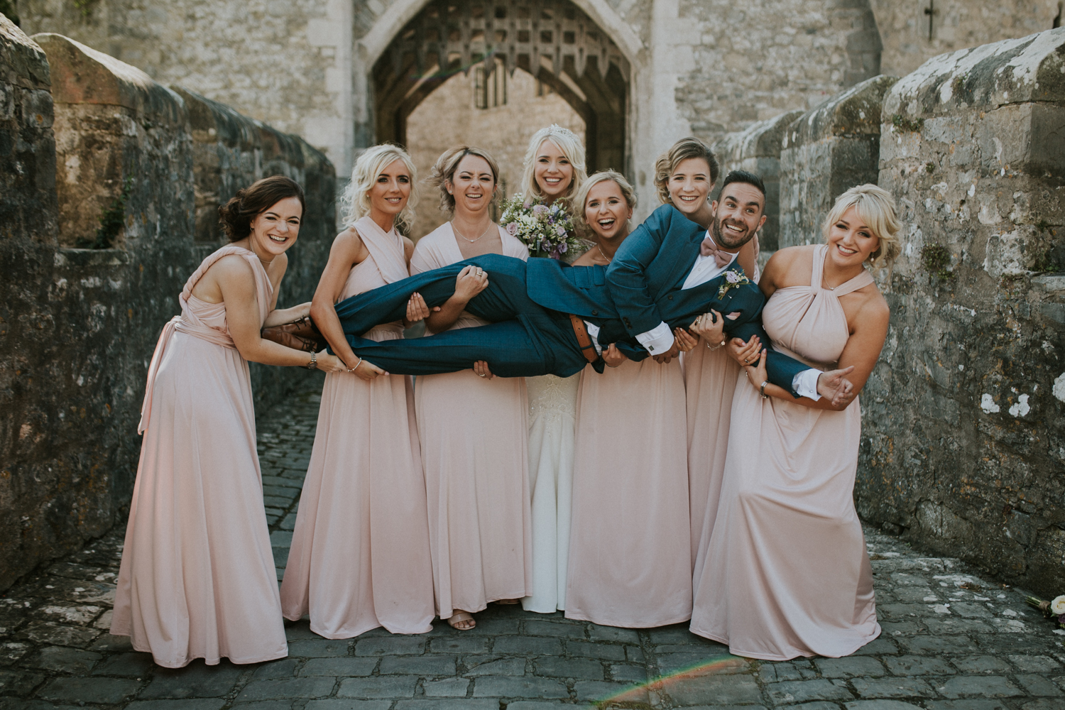 bridesmaids lifting the groom