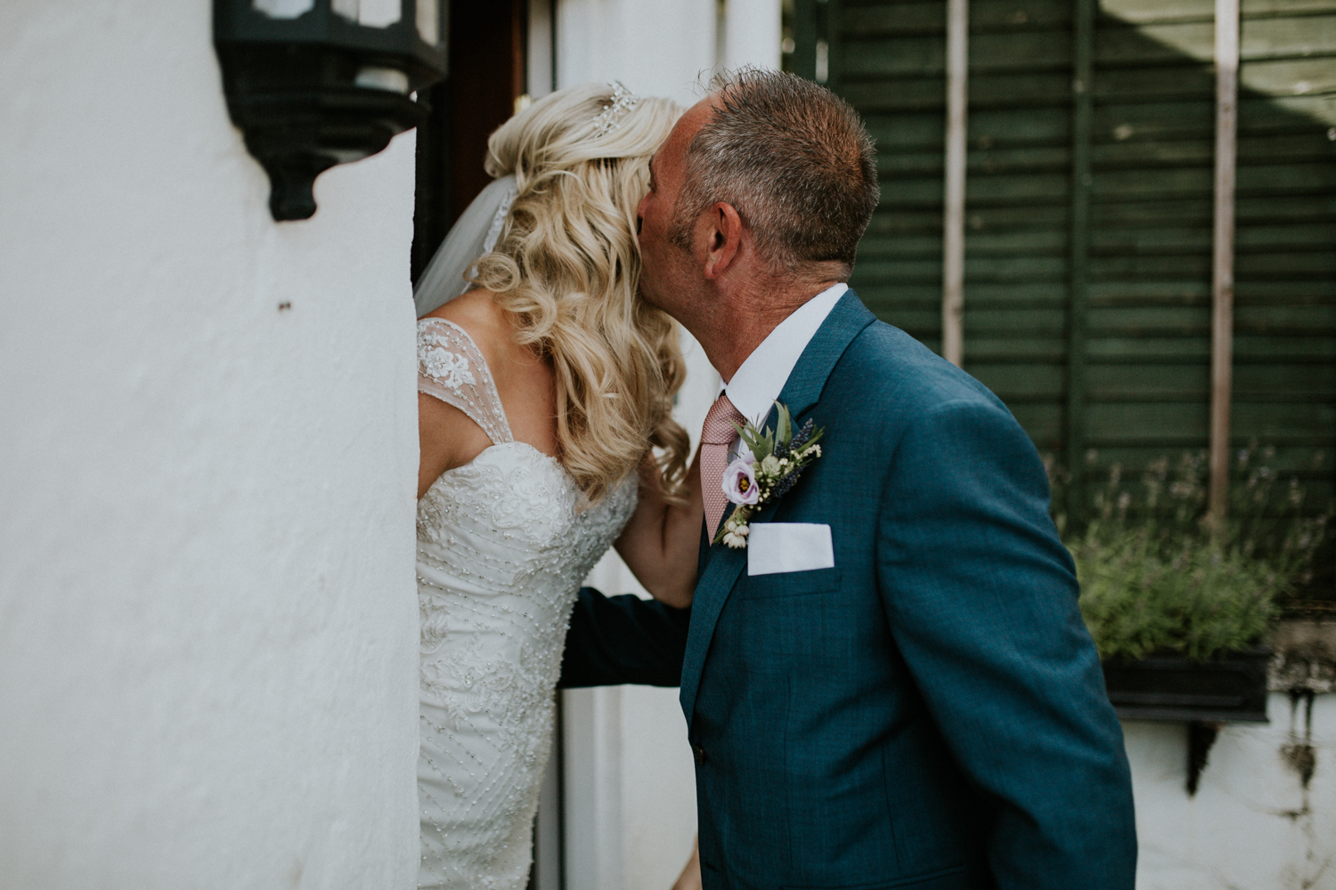 father of the bride kisses bride on cheek