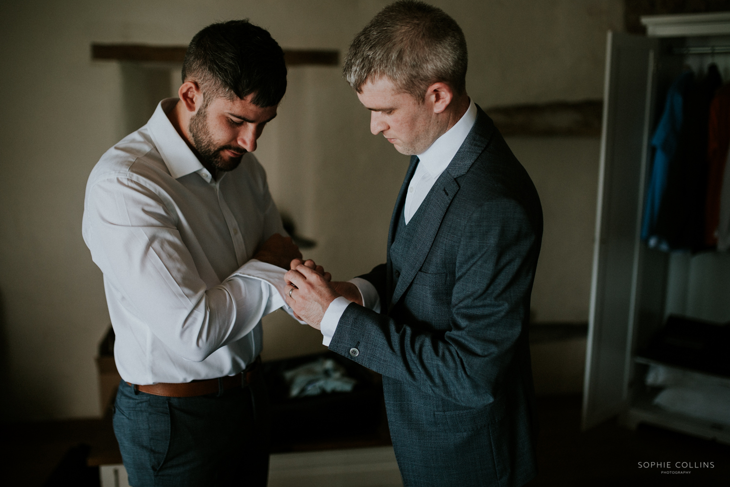 groom putting cufflinks on