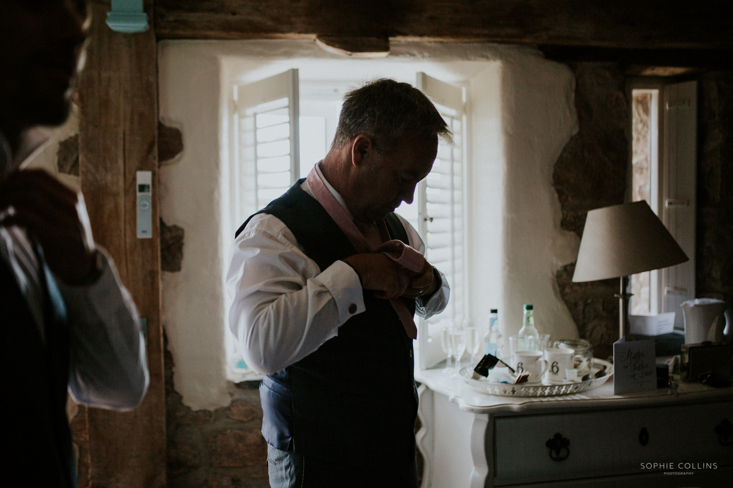 groomsman doing his tie