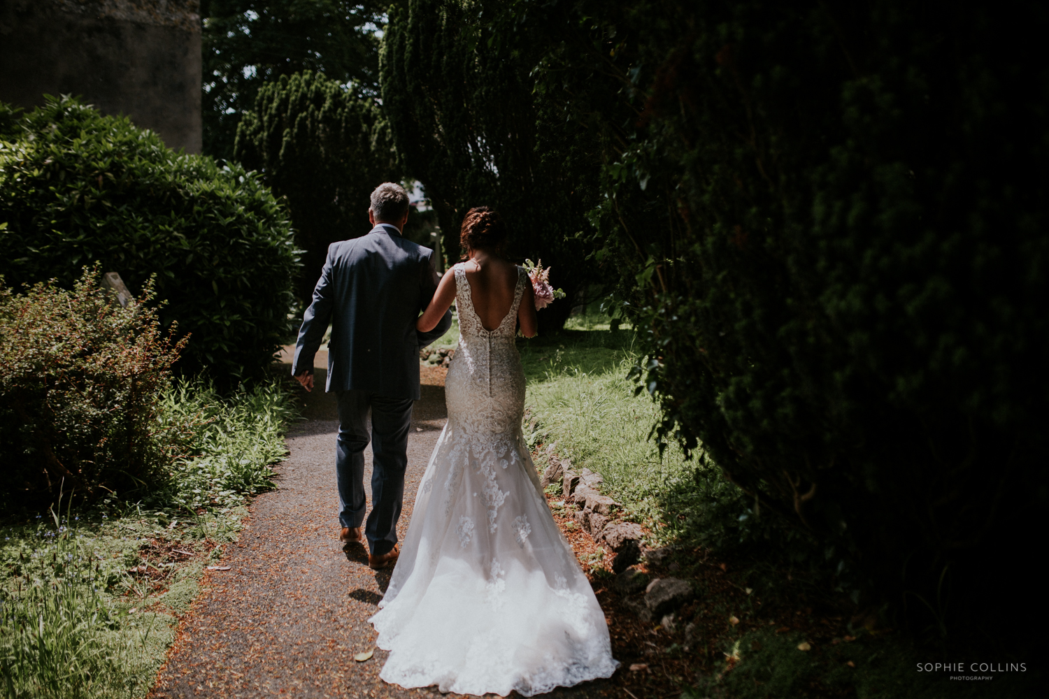 father of bride and bride walking to the church 