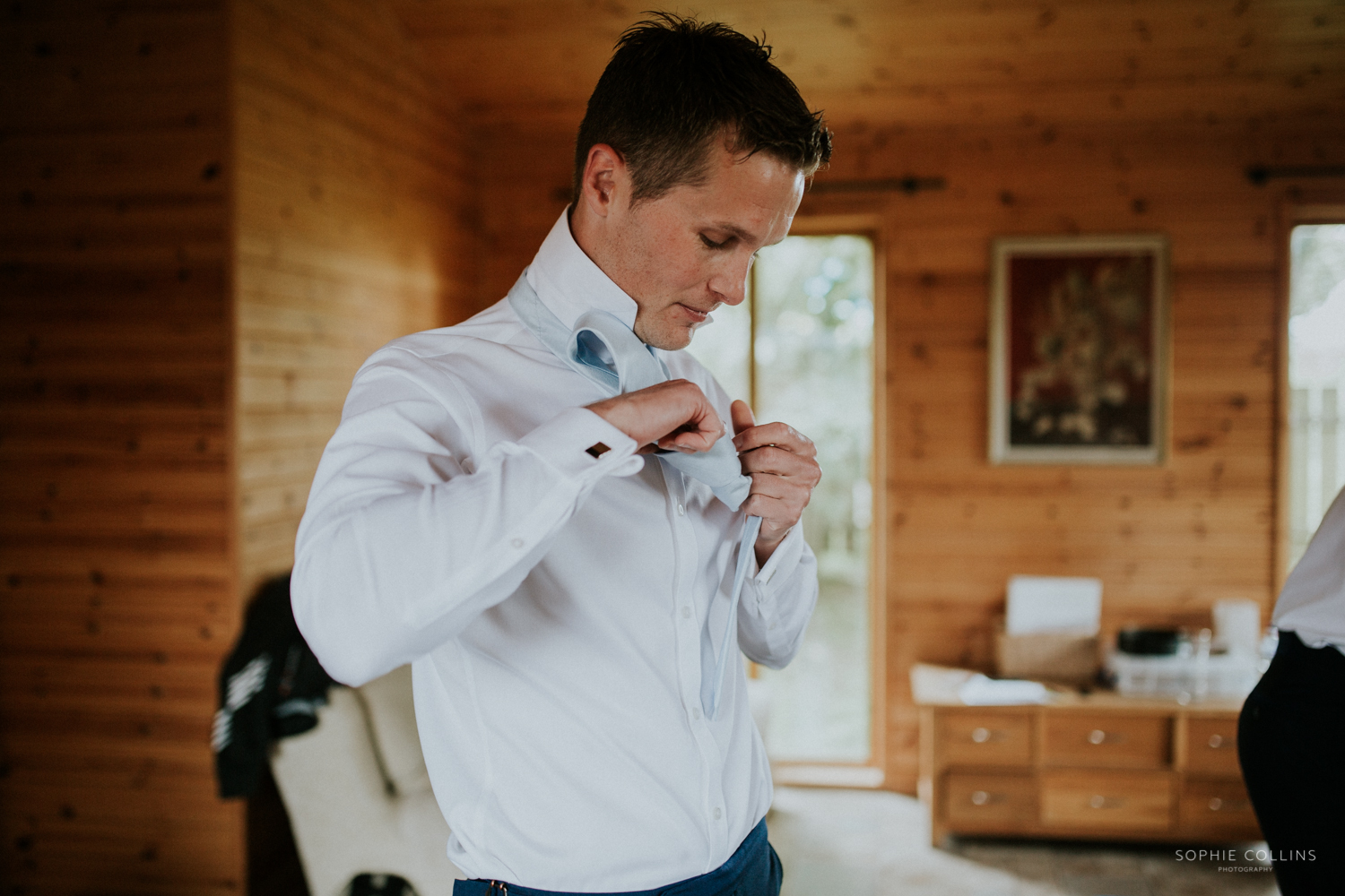 groom doing up his shirt