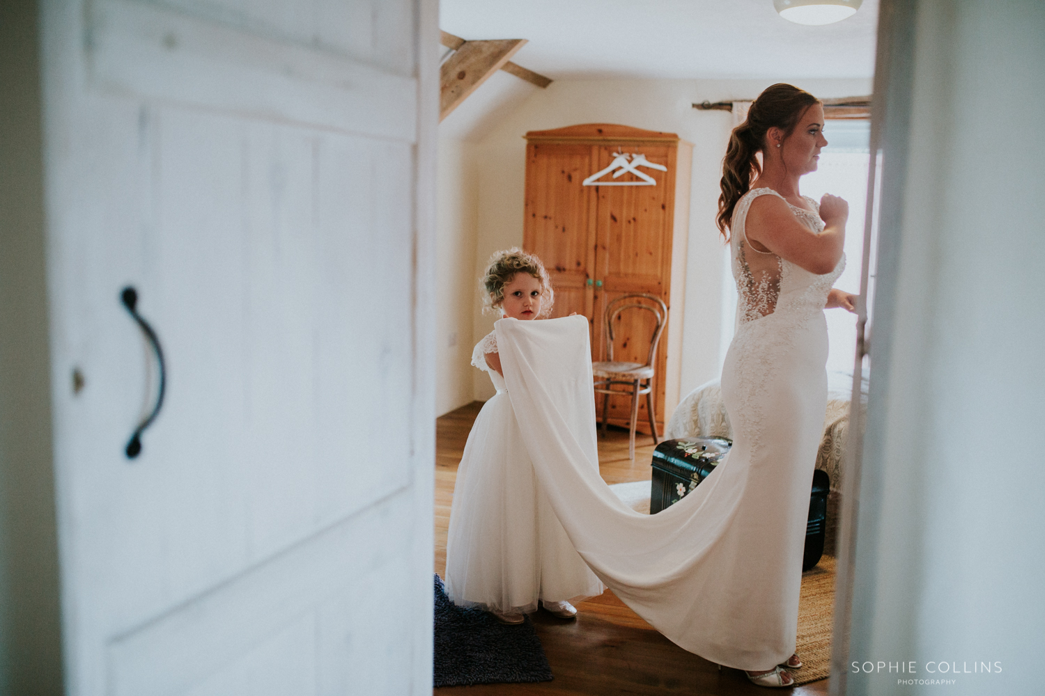 flower girl holding brides dress