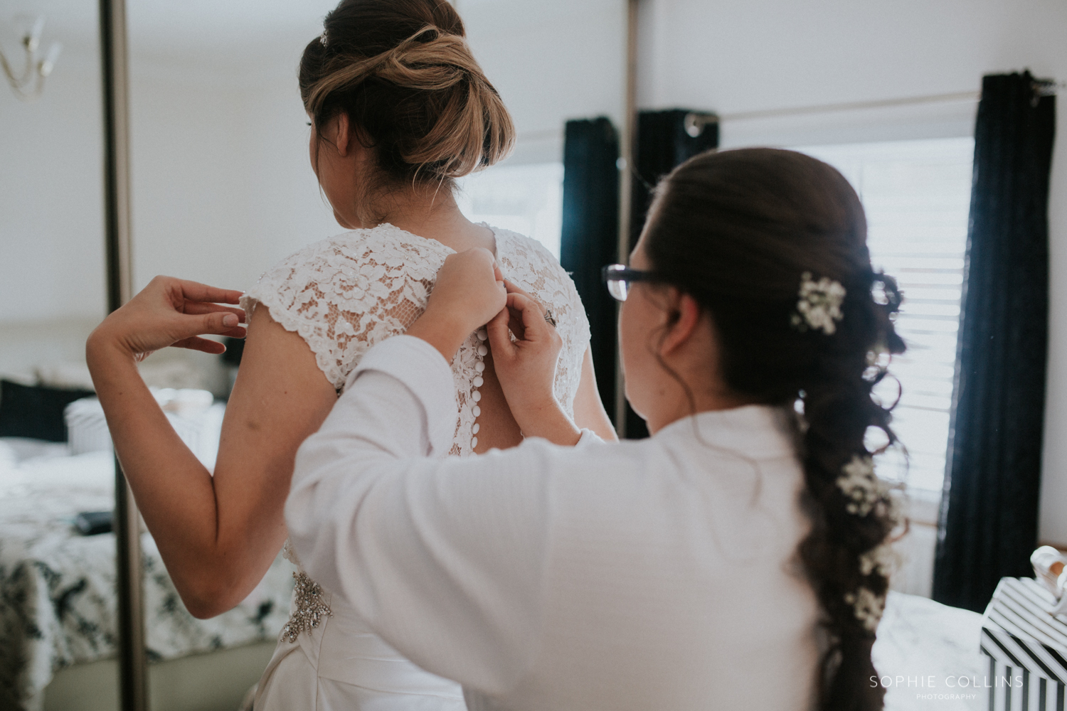 bridesmaids doing brides dress