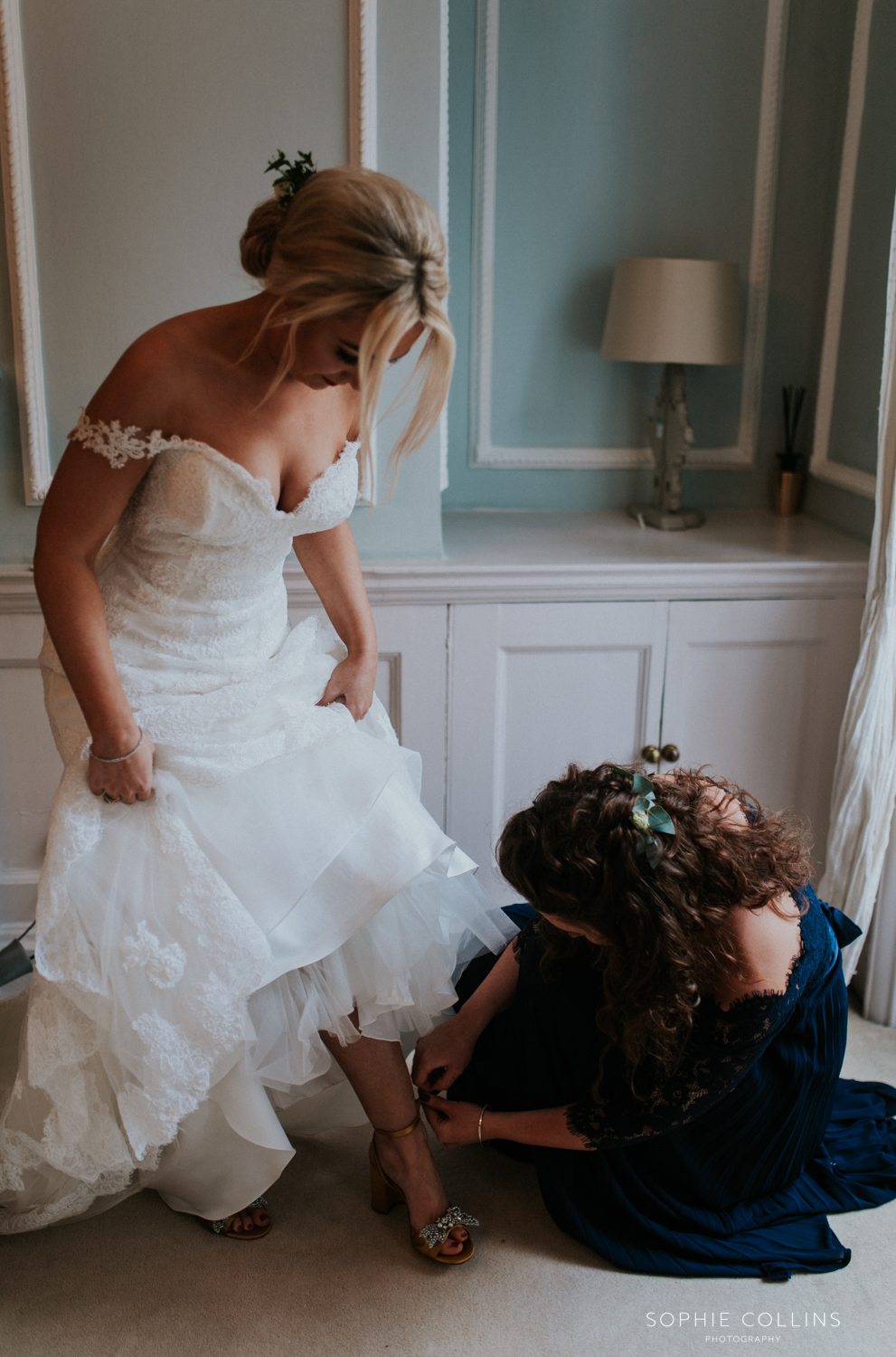 sister doing brides shoes