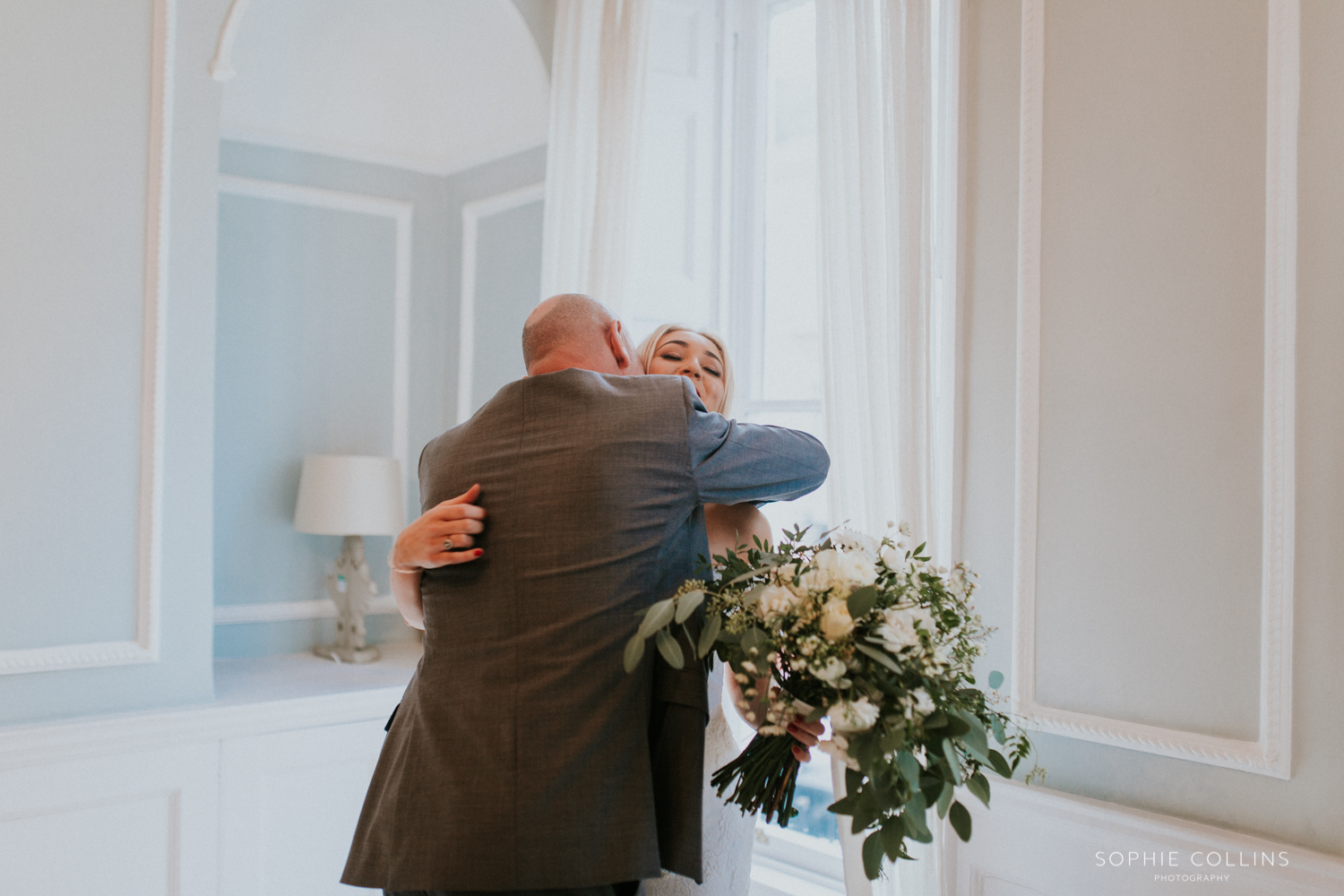 father of the bride hugging bride