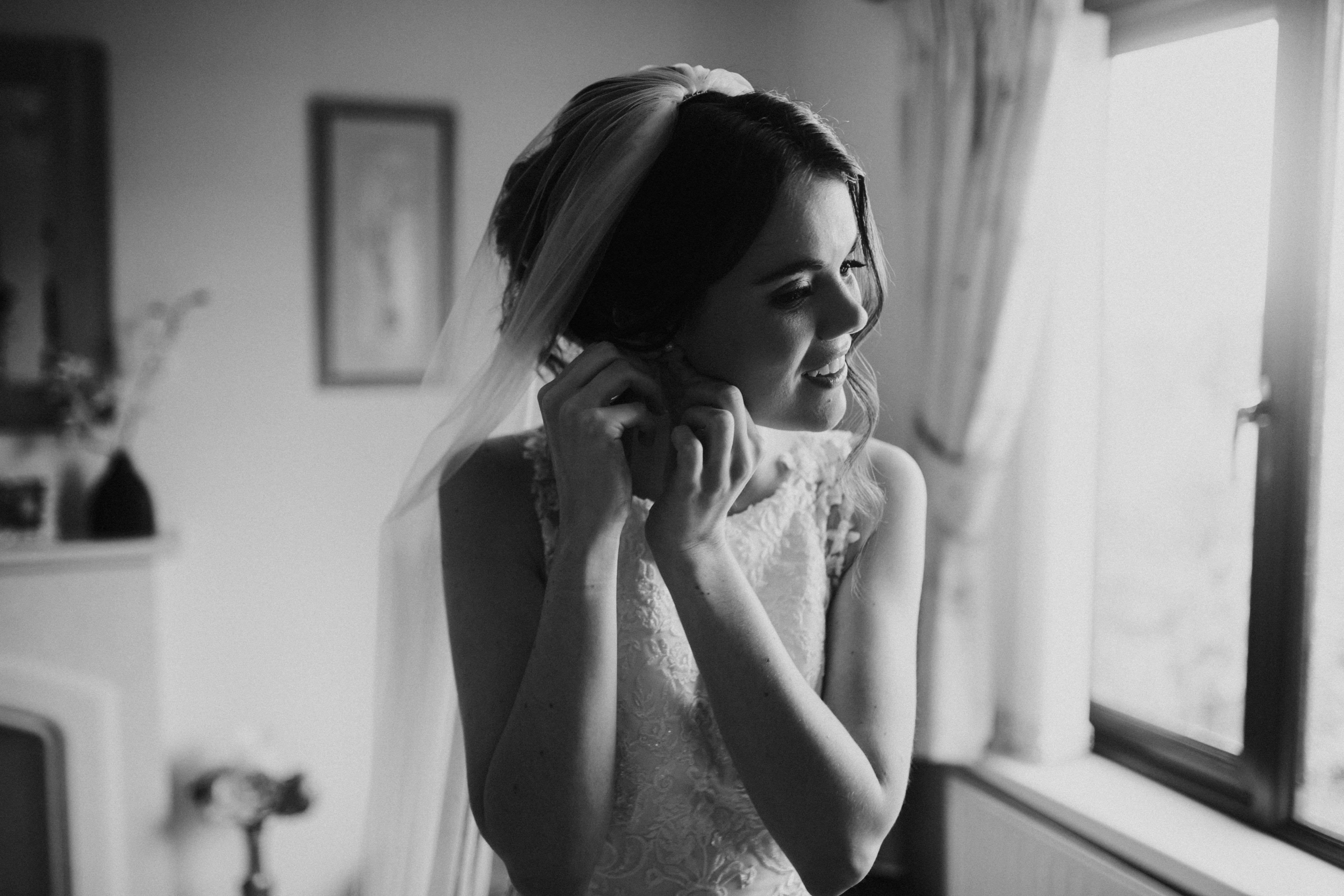 bride putting earrings in 