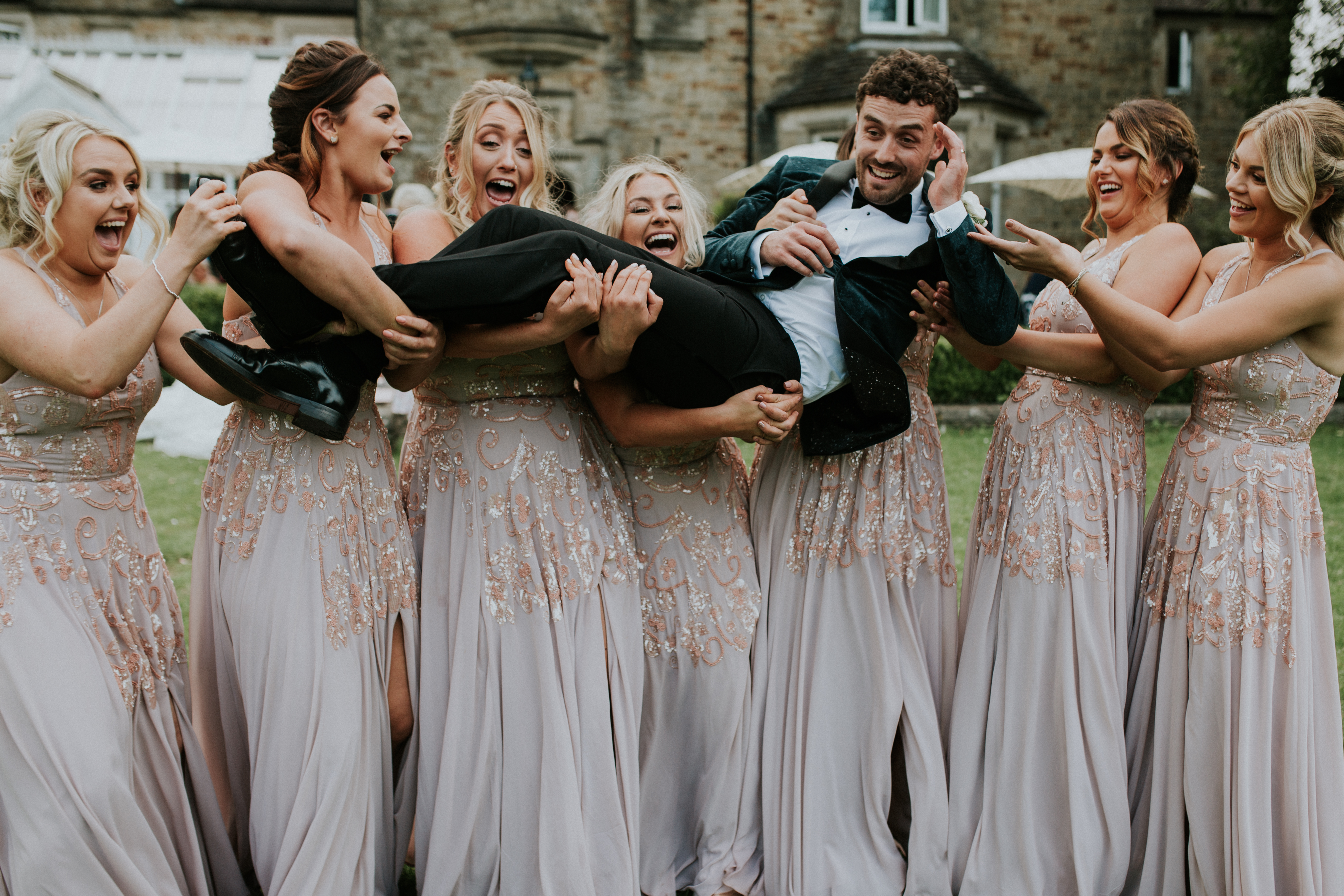 bridesmaids picking up the groom 