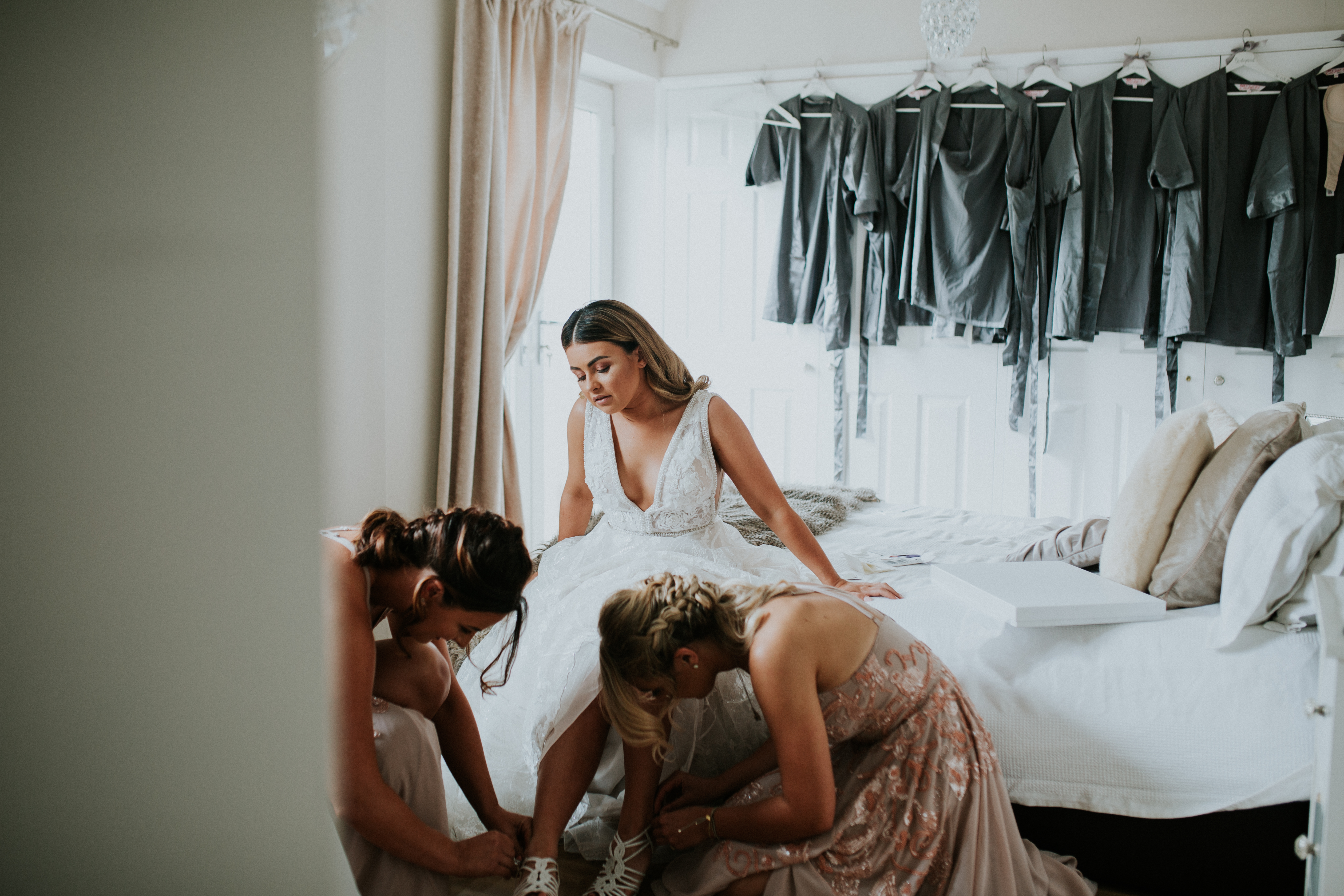 bridesmaids doing brides shoes 