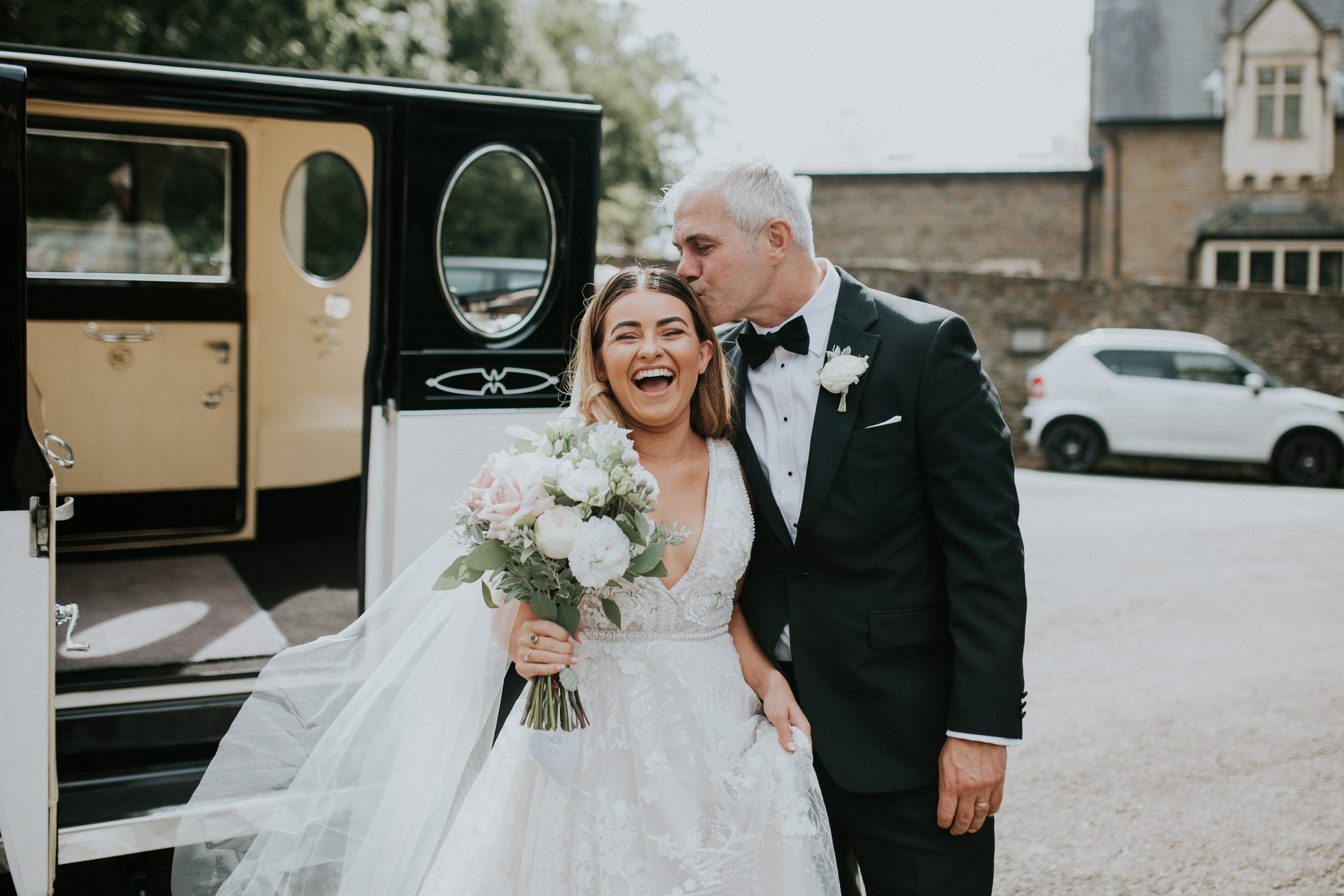 father of the bride kissing brides head 