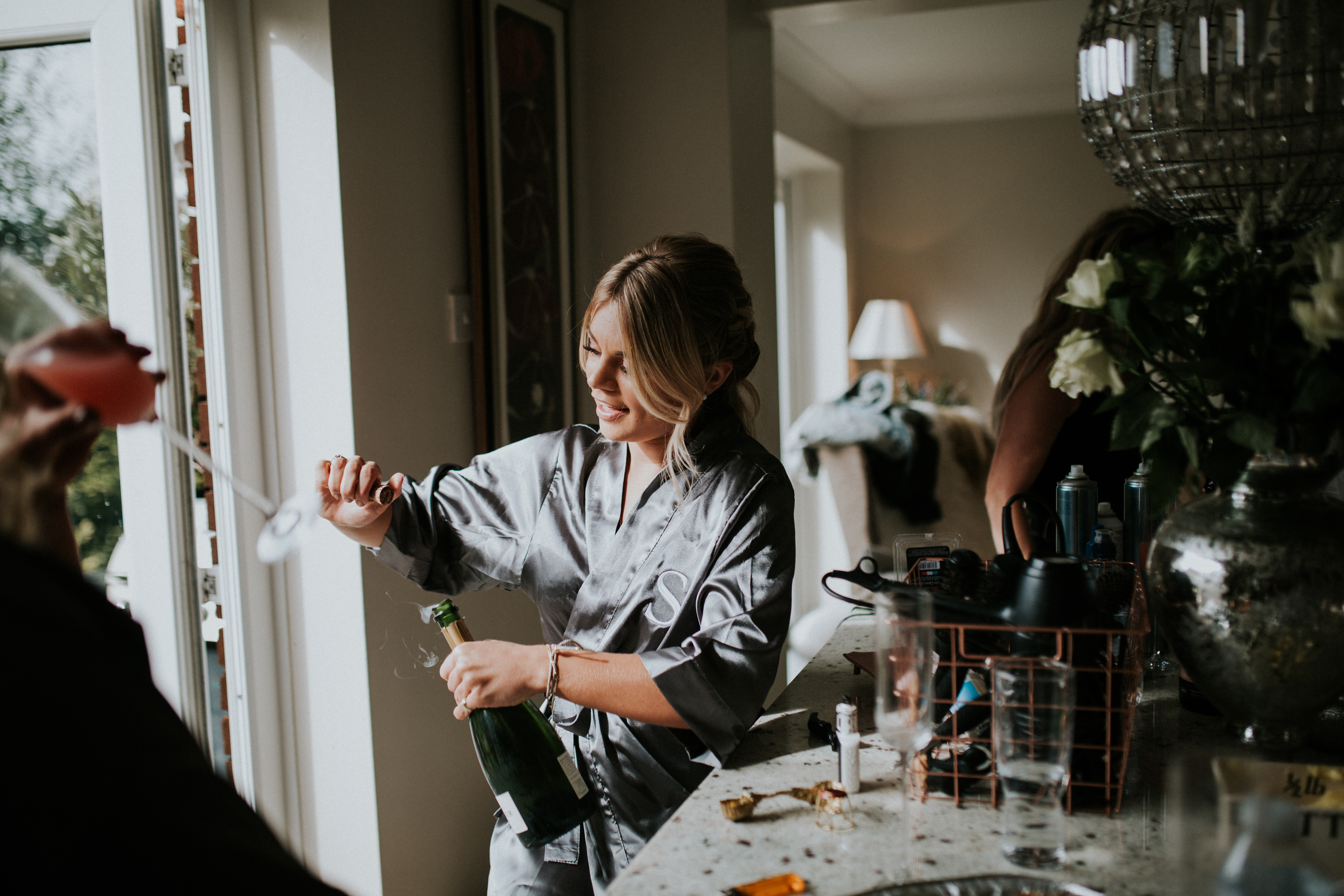 bridesmaid opening champagne 