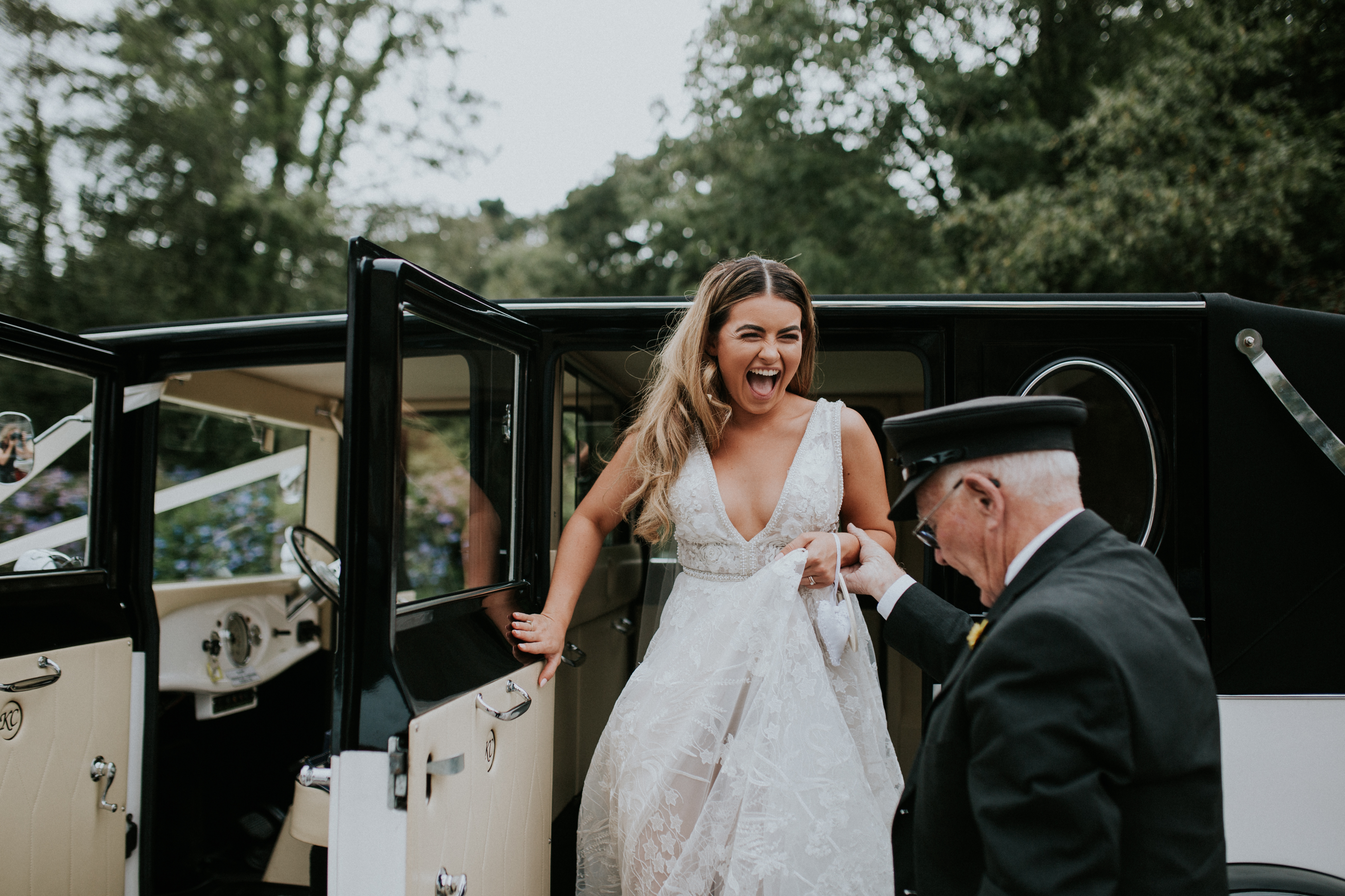 bride stepping out of wedding car 