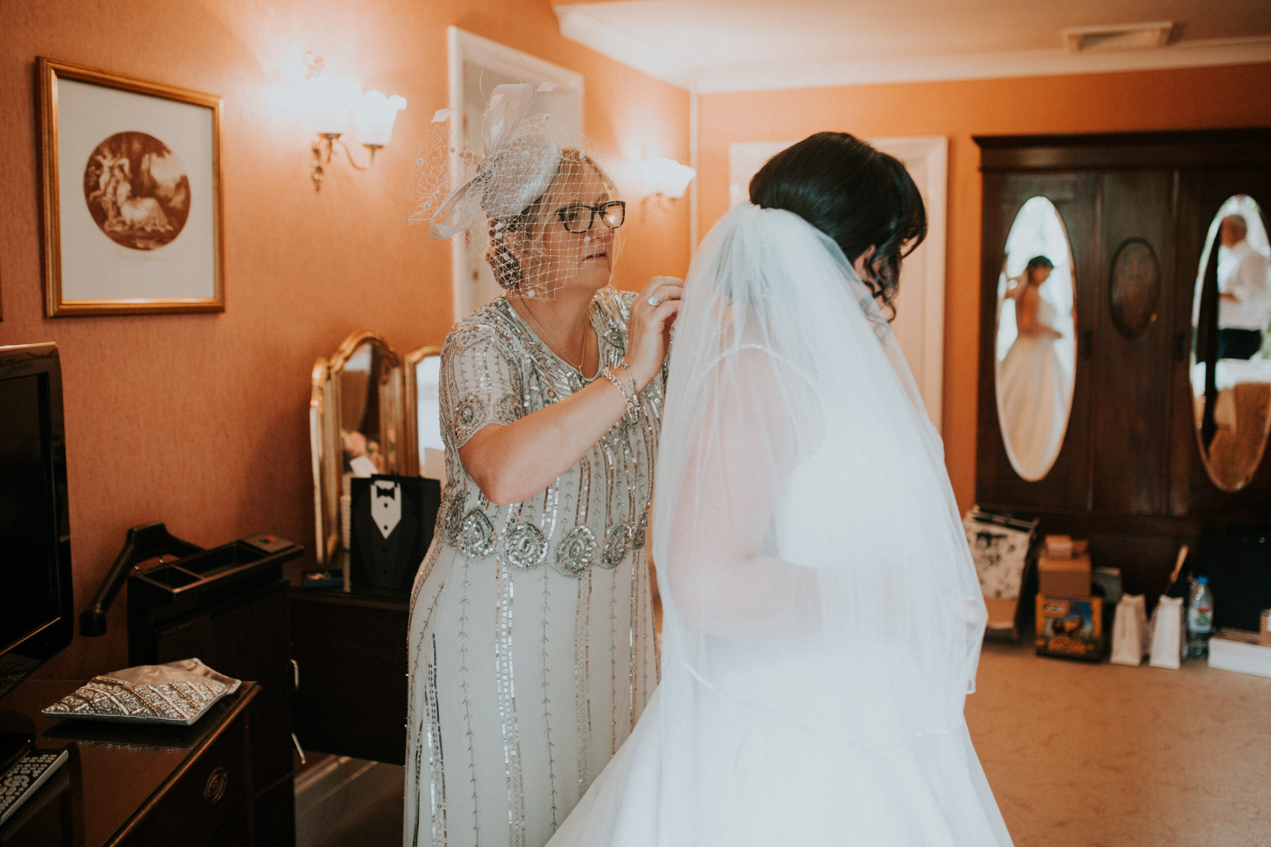 mother doing brides dress 