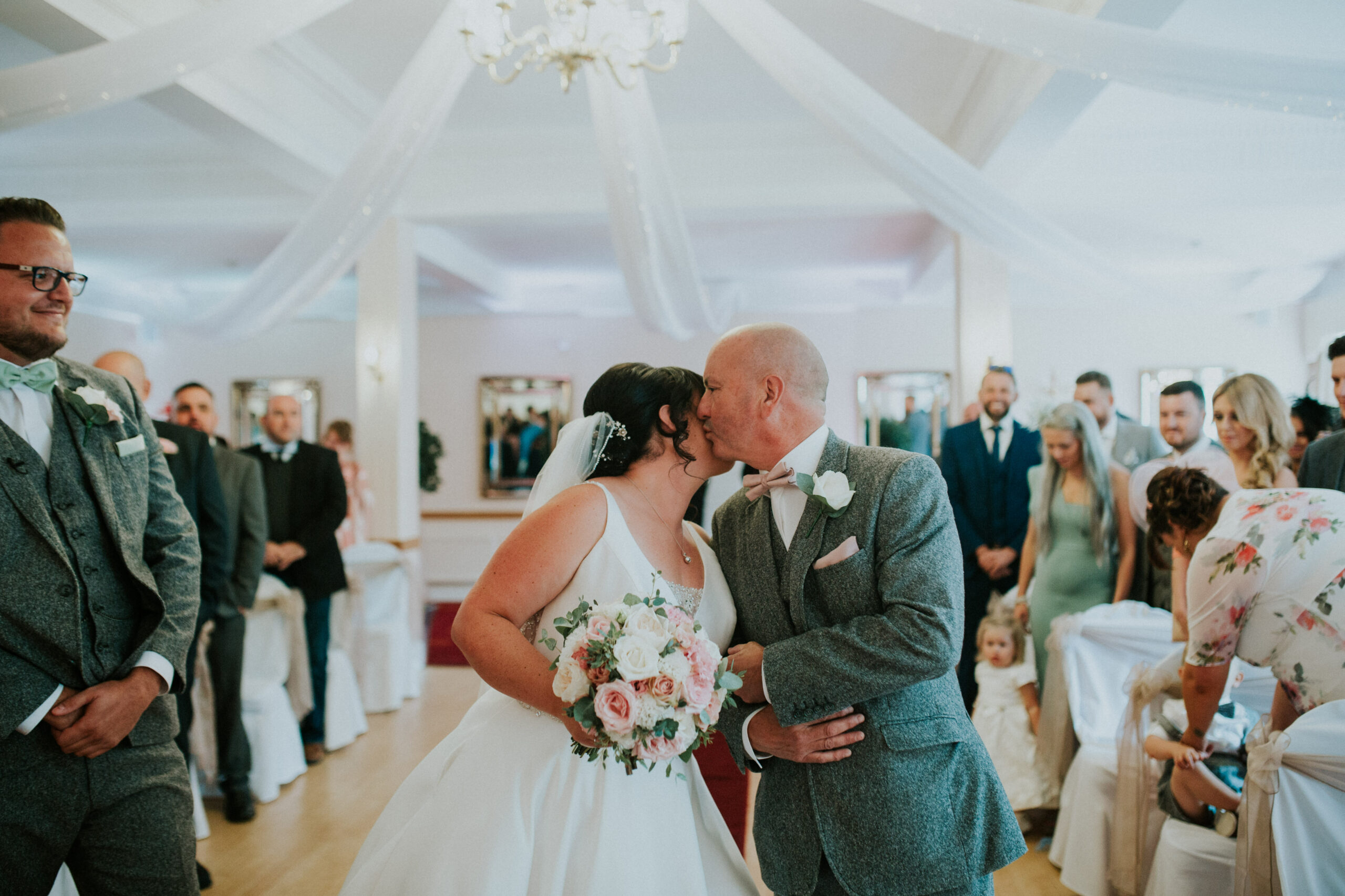 father of the bride kissing bride 