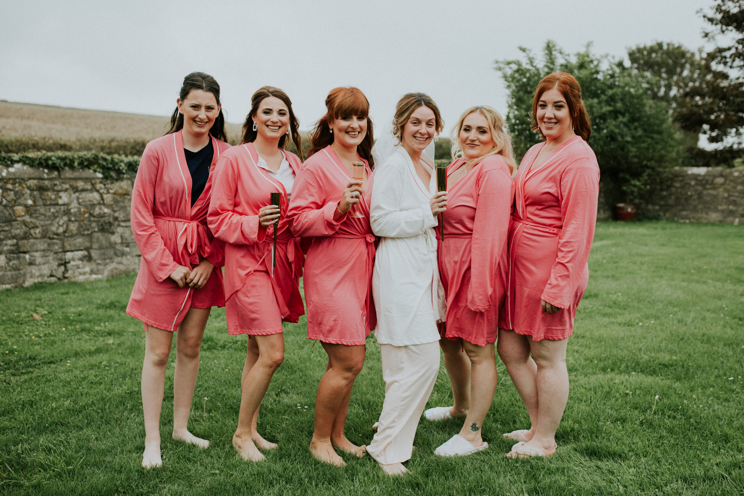 bridesmaids group shot in a field 
