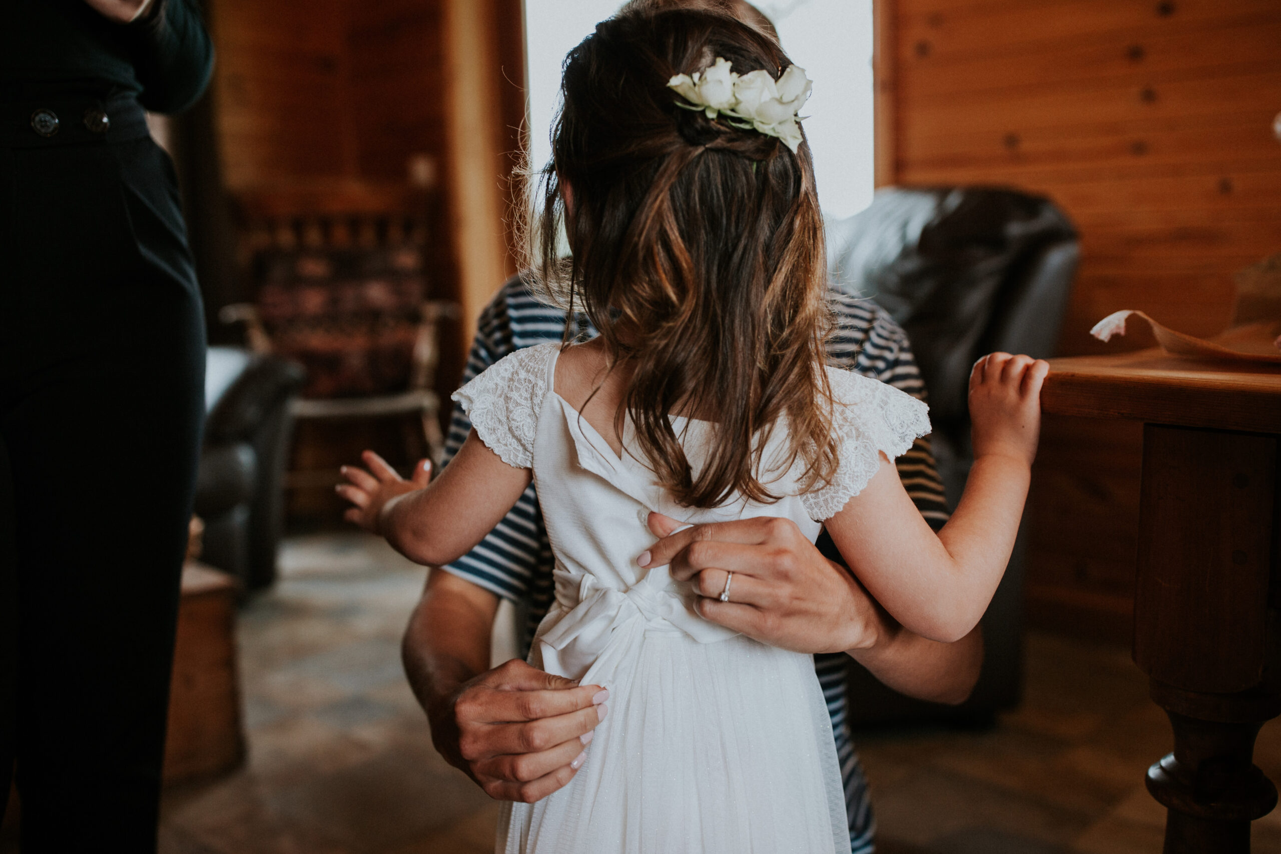 bride doing the back of the flower girls dress