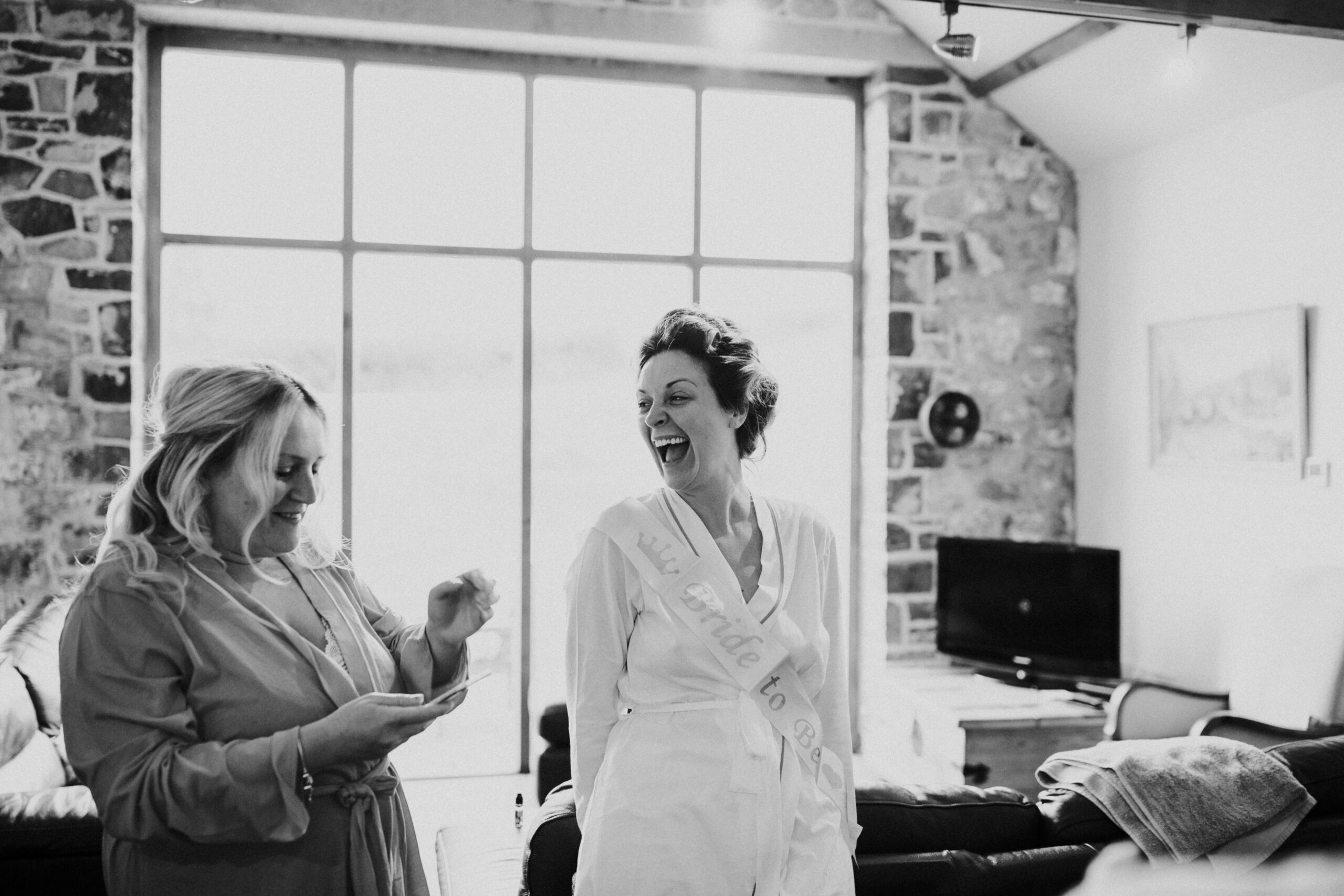 bride laughing with the bridesmaid 