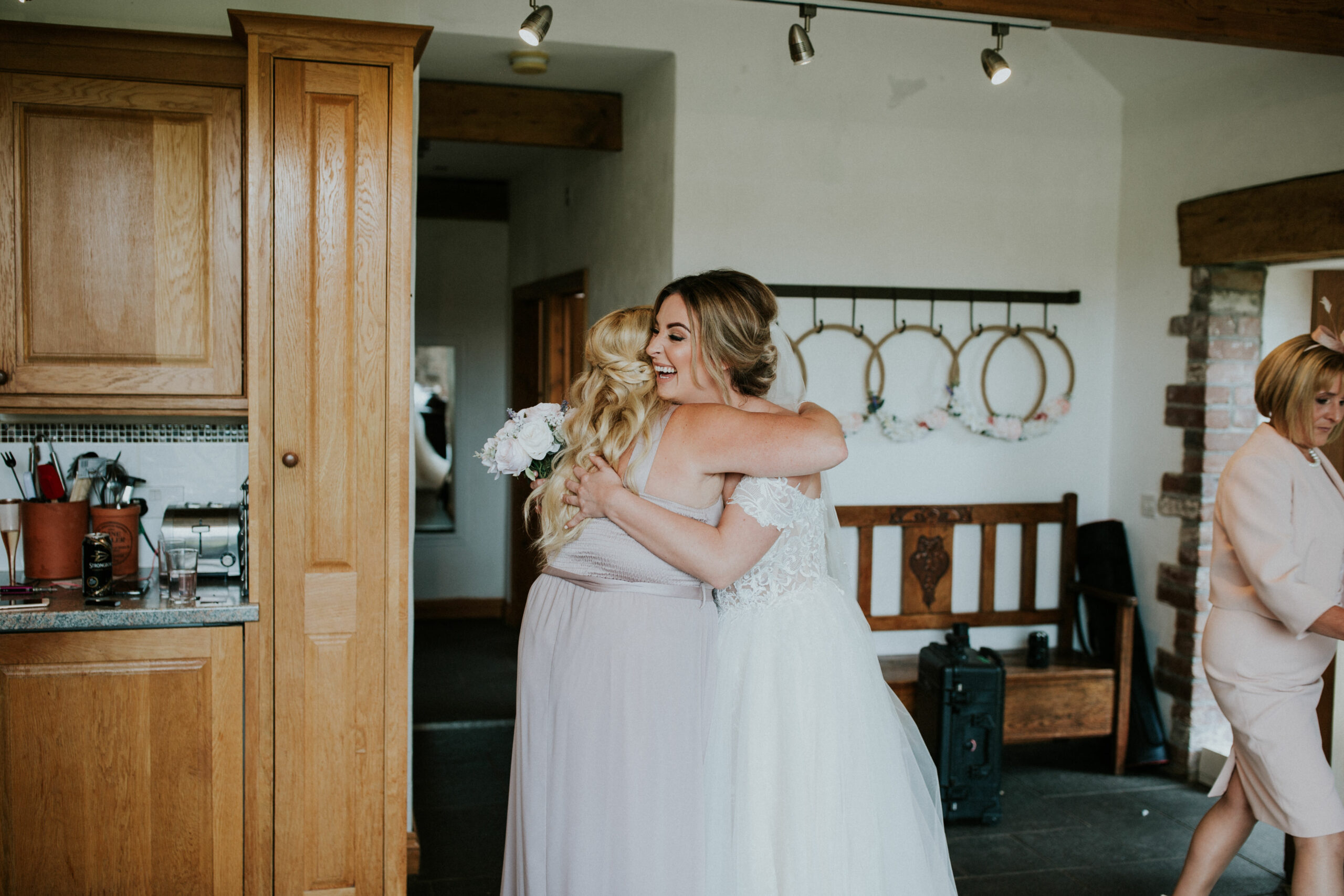 bridesmaid hugging the bride