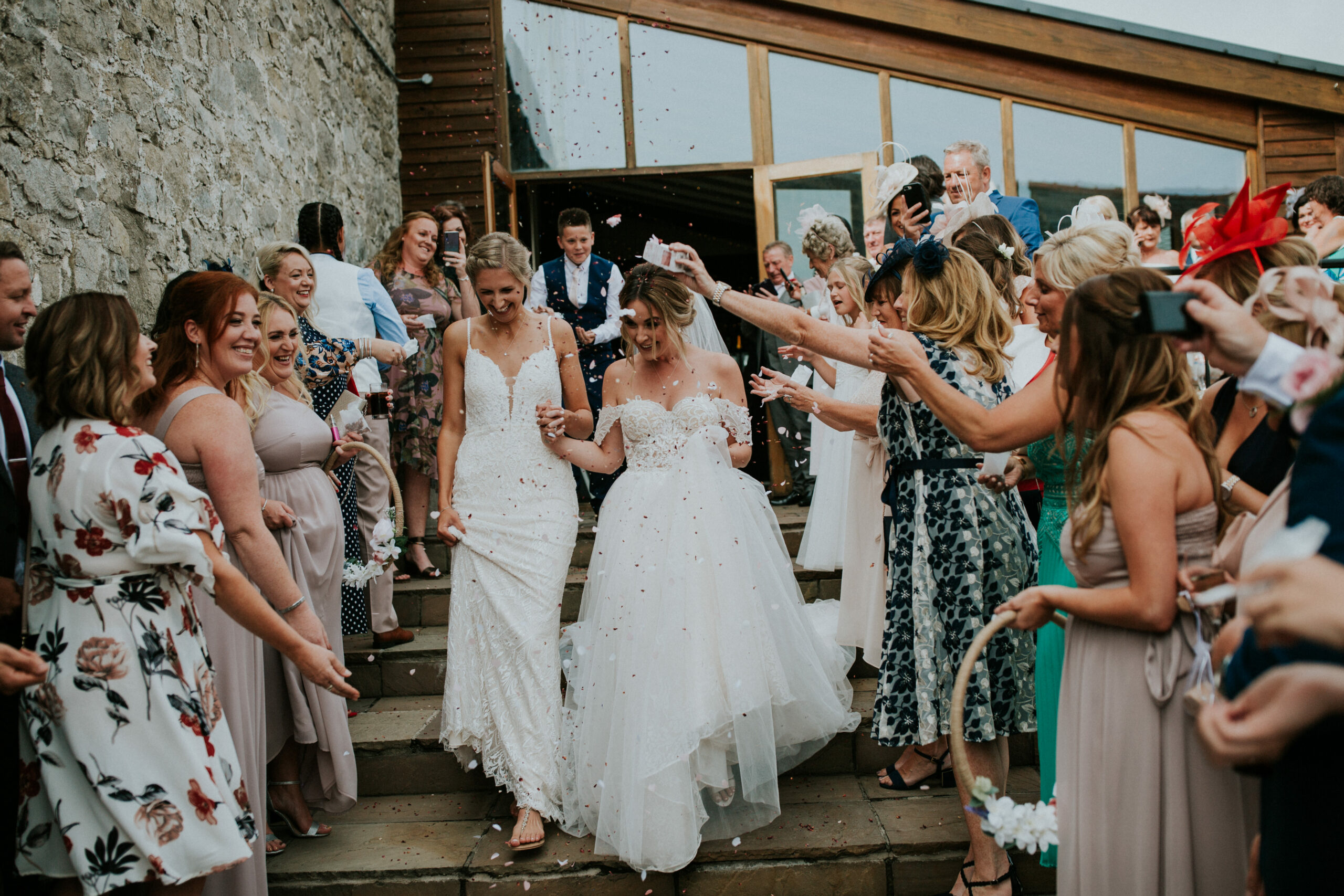 brides walking whilst guests are throwing confetti 