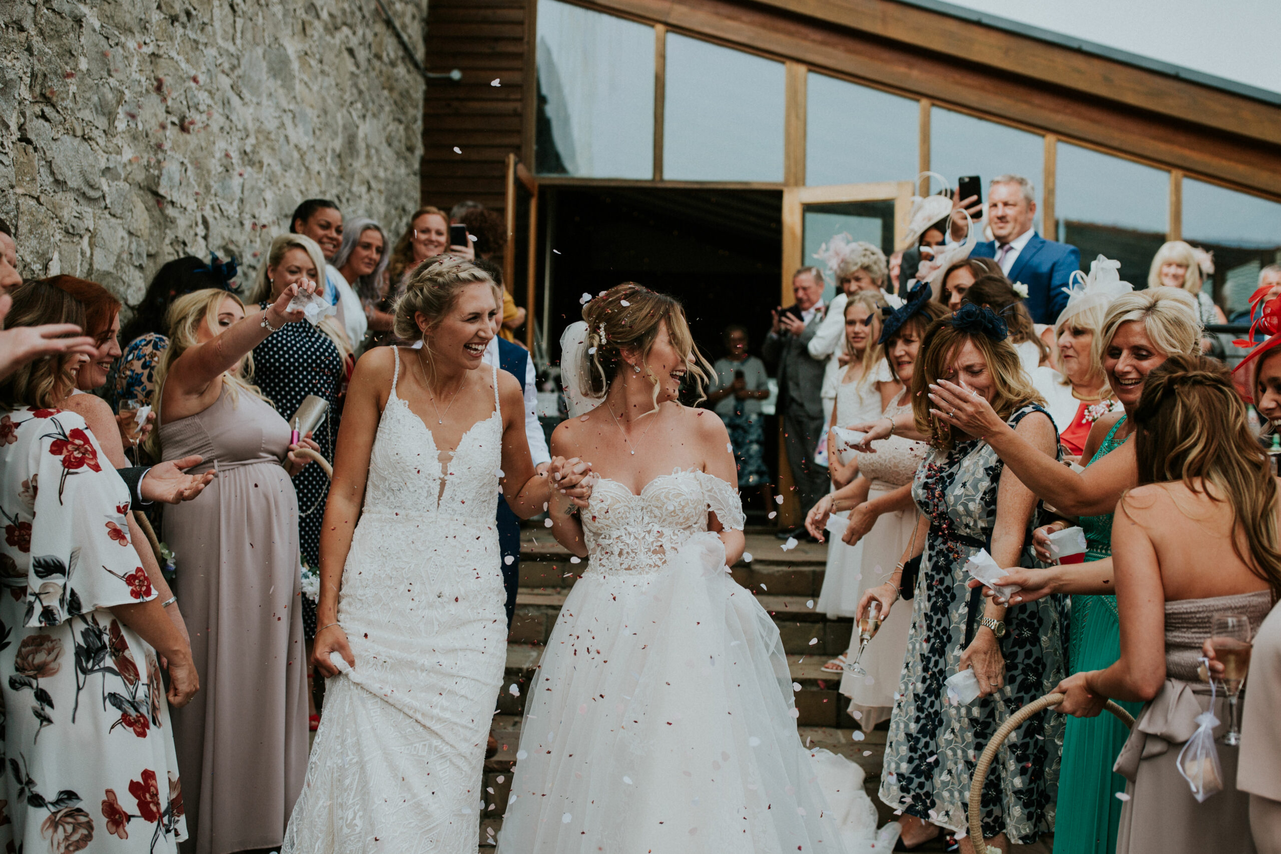 brides walking whilst guests are throwing confetti 