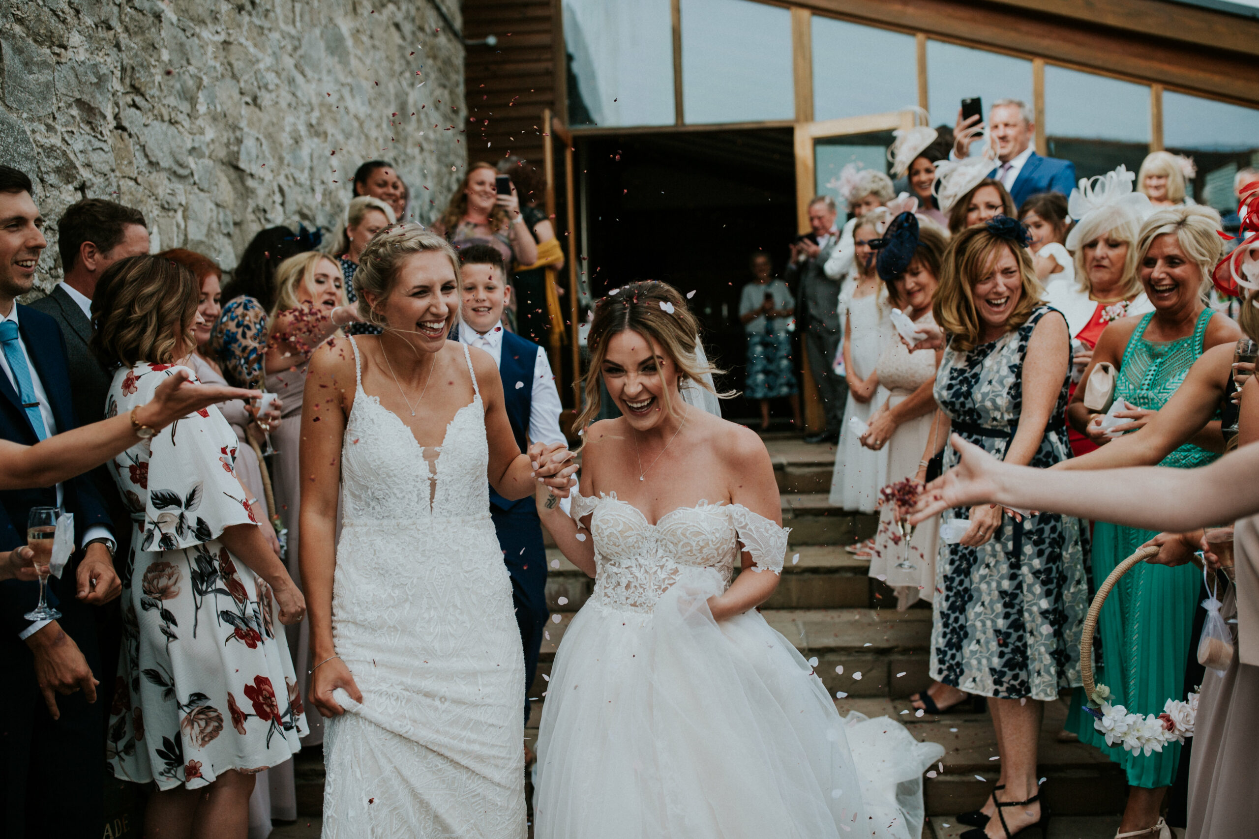 brides walking whilst guests are throwing confetti 