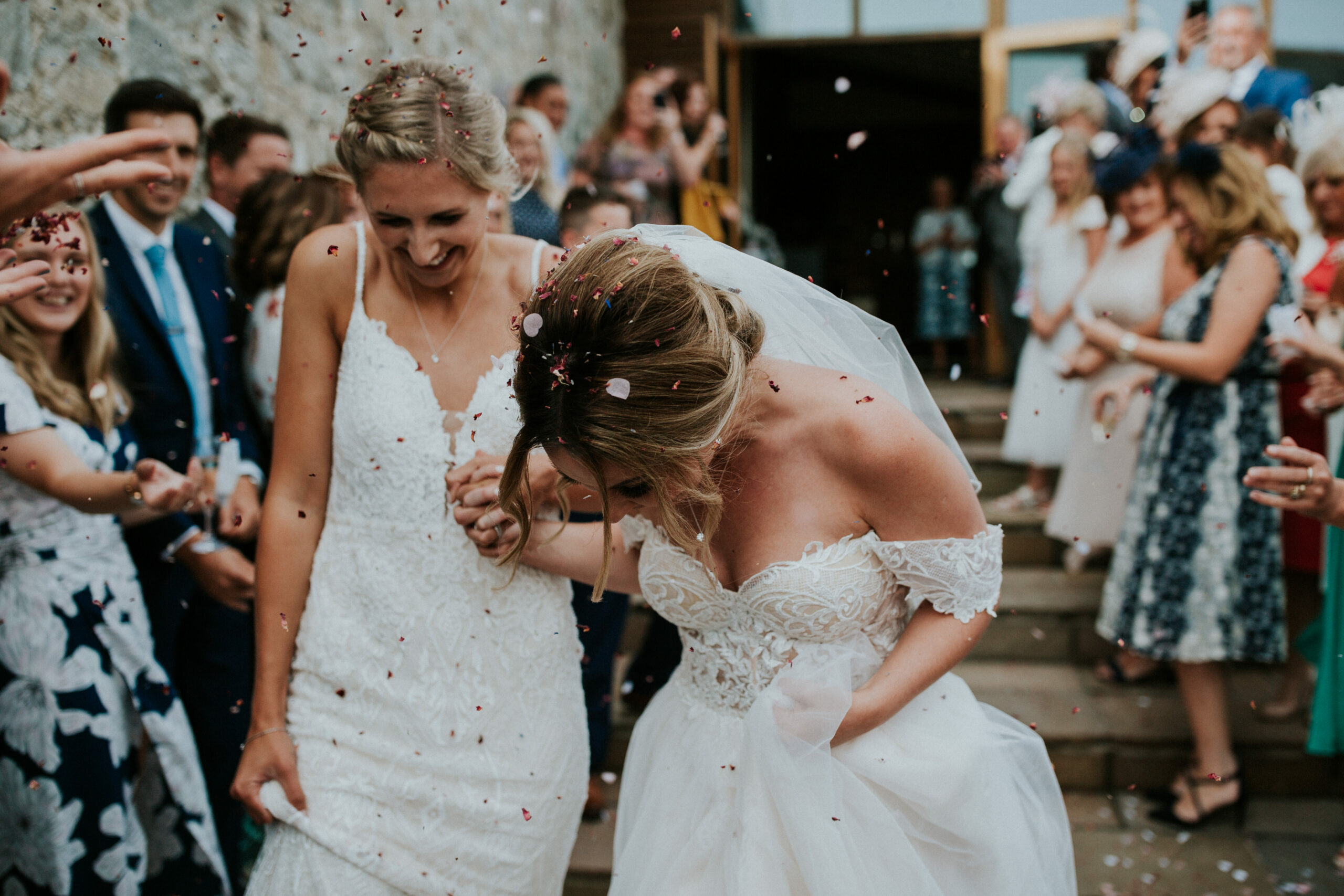 brides walking whilst guests are throwing confetti 