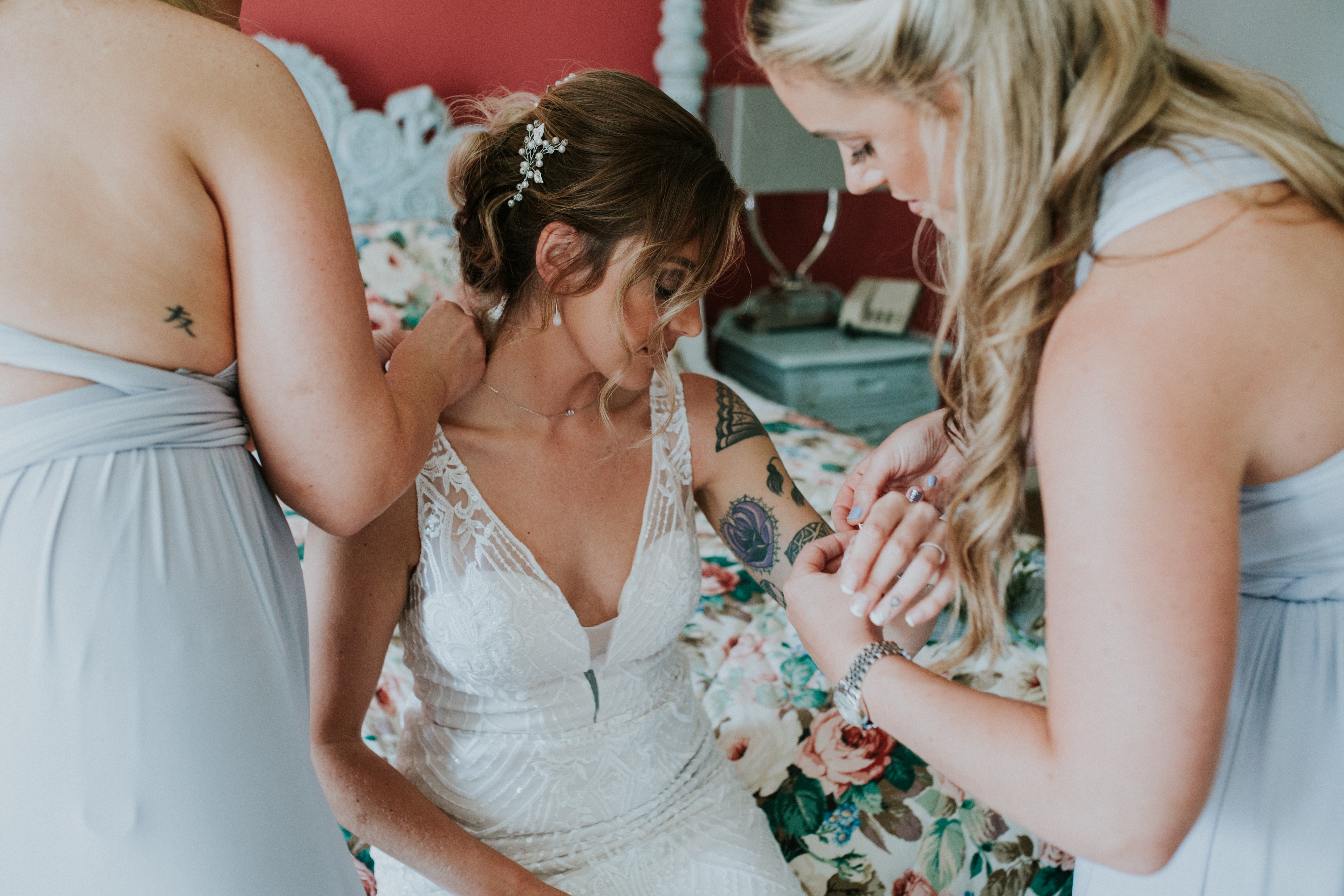 bridesmaids putting on brides jewellery 