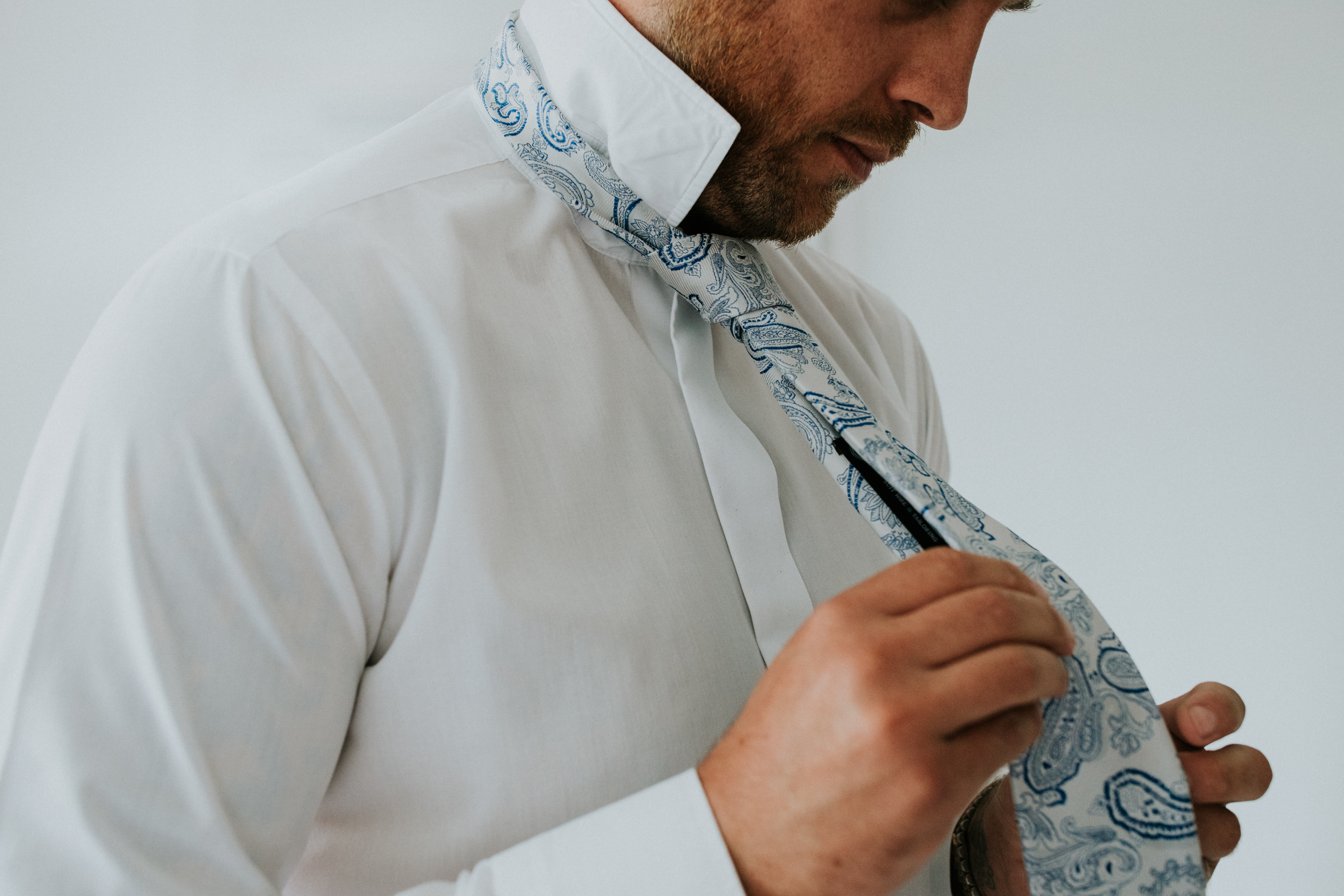 groom doing up his tie 