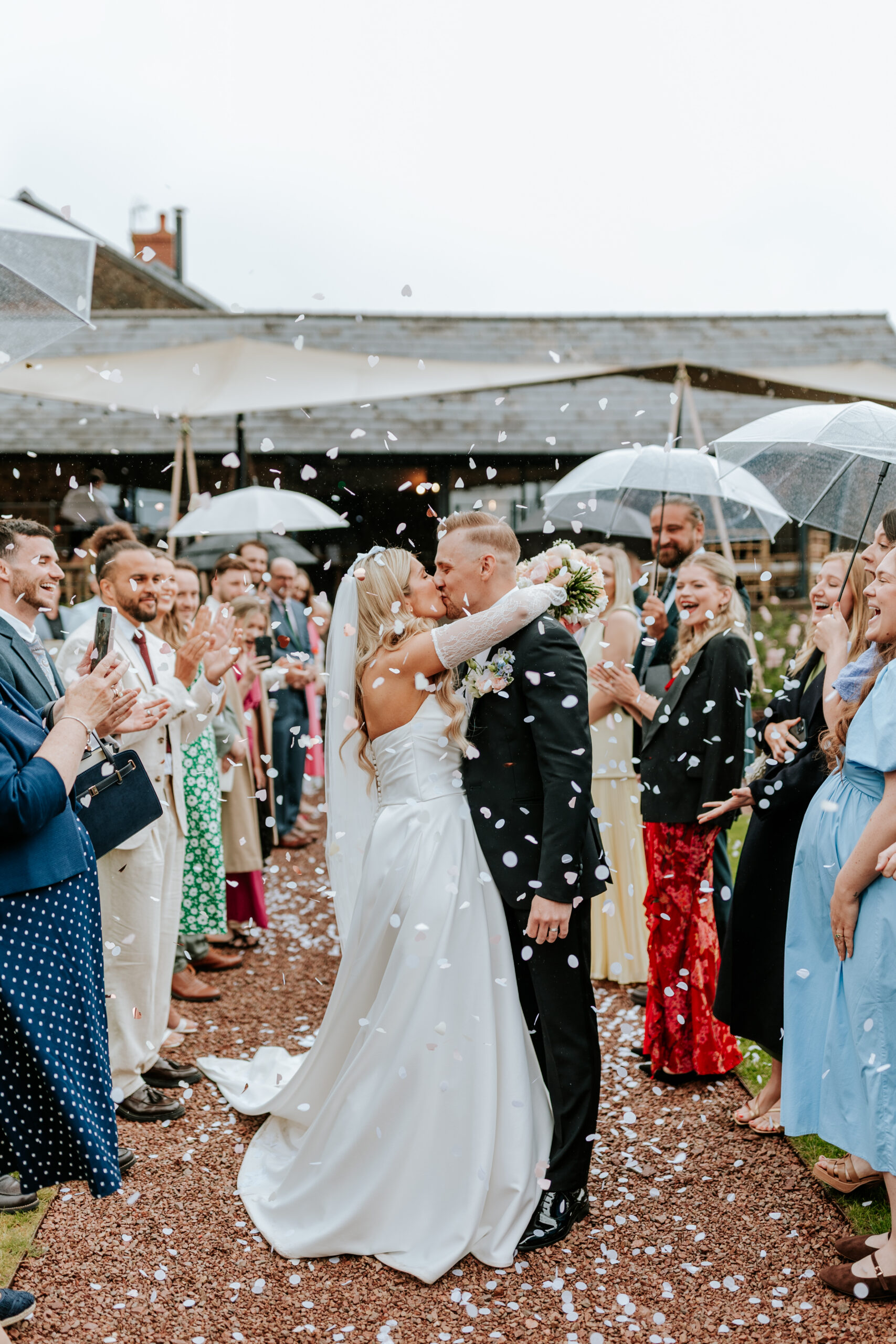 bride and groom kissing during confetti
